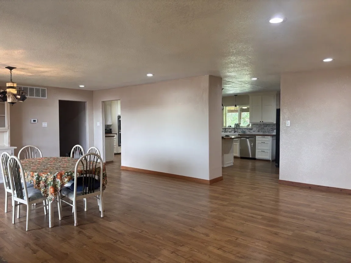 Open-concept living space featuring wood-finish flooring, recessed lighting, and a neutral color palette
(AI Enhanced / Object removal)