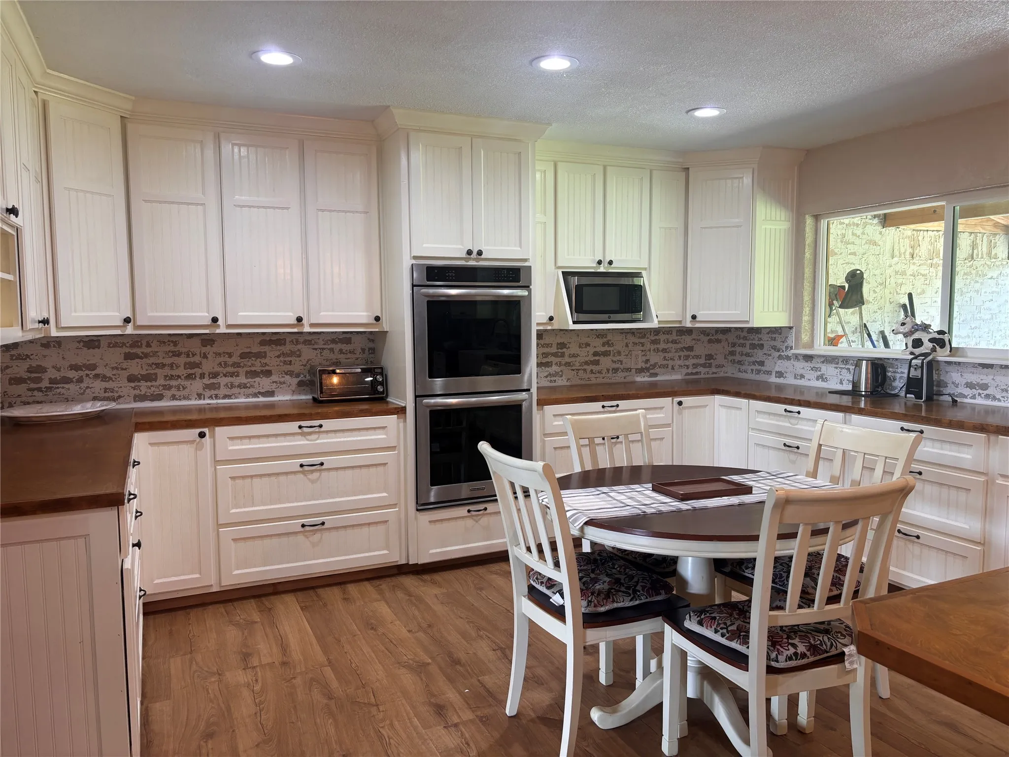 White cabinetry with beadboard paneling and dark hardware