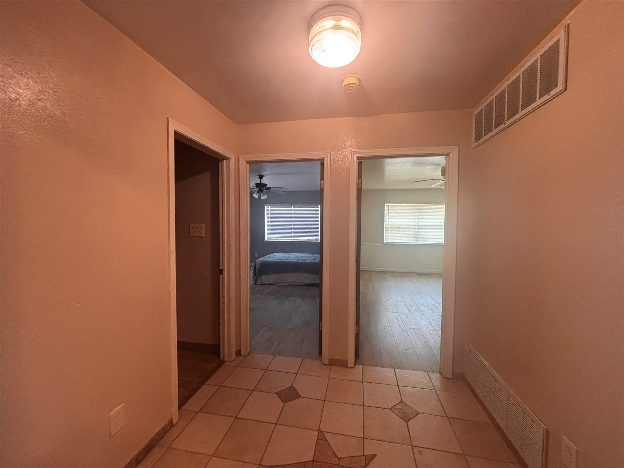Entryway with tiled flooring featuring a star motif, flush-mount ceiling light, and access to additional rooms