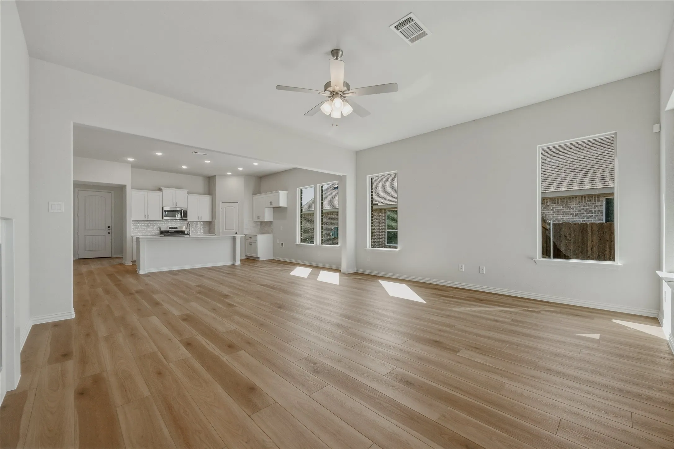 Expansive room featuring wood-finish flooring, recessed lighting, and a ceiling fan