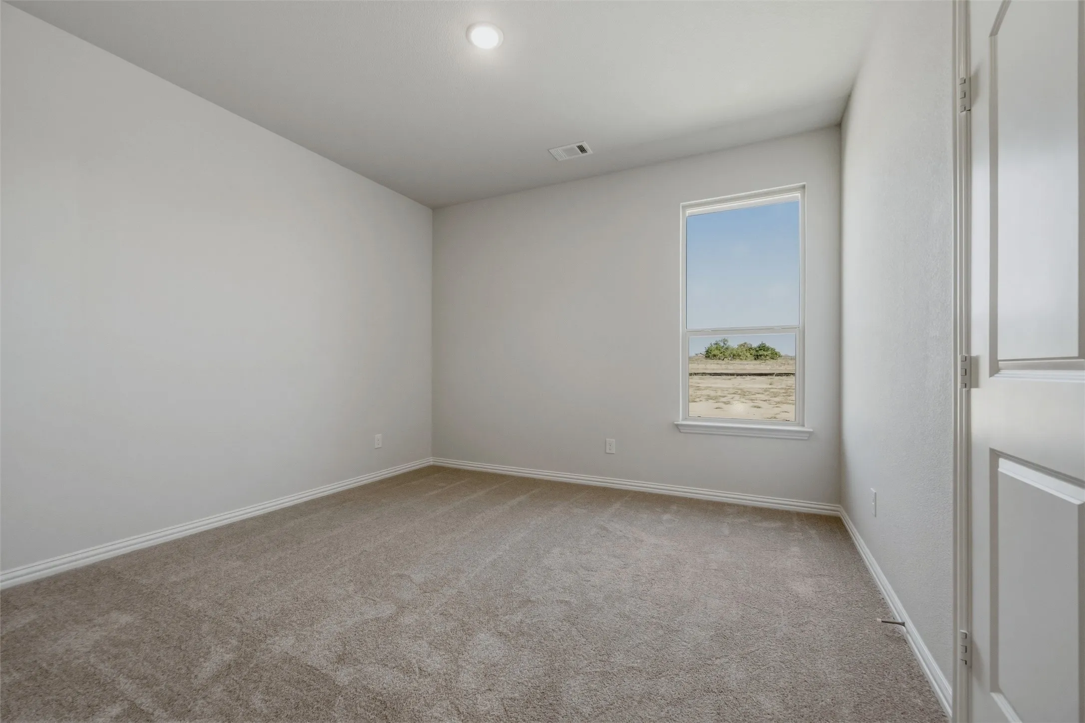 Neutral wall tones, recessed ceiling light, and carpeted flooring