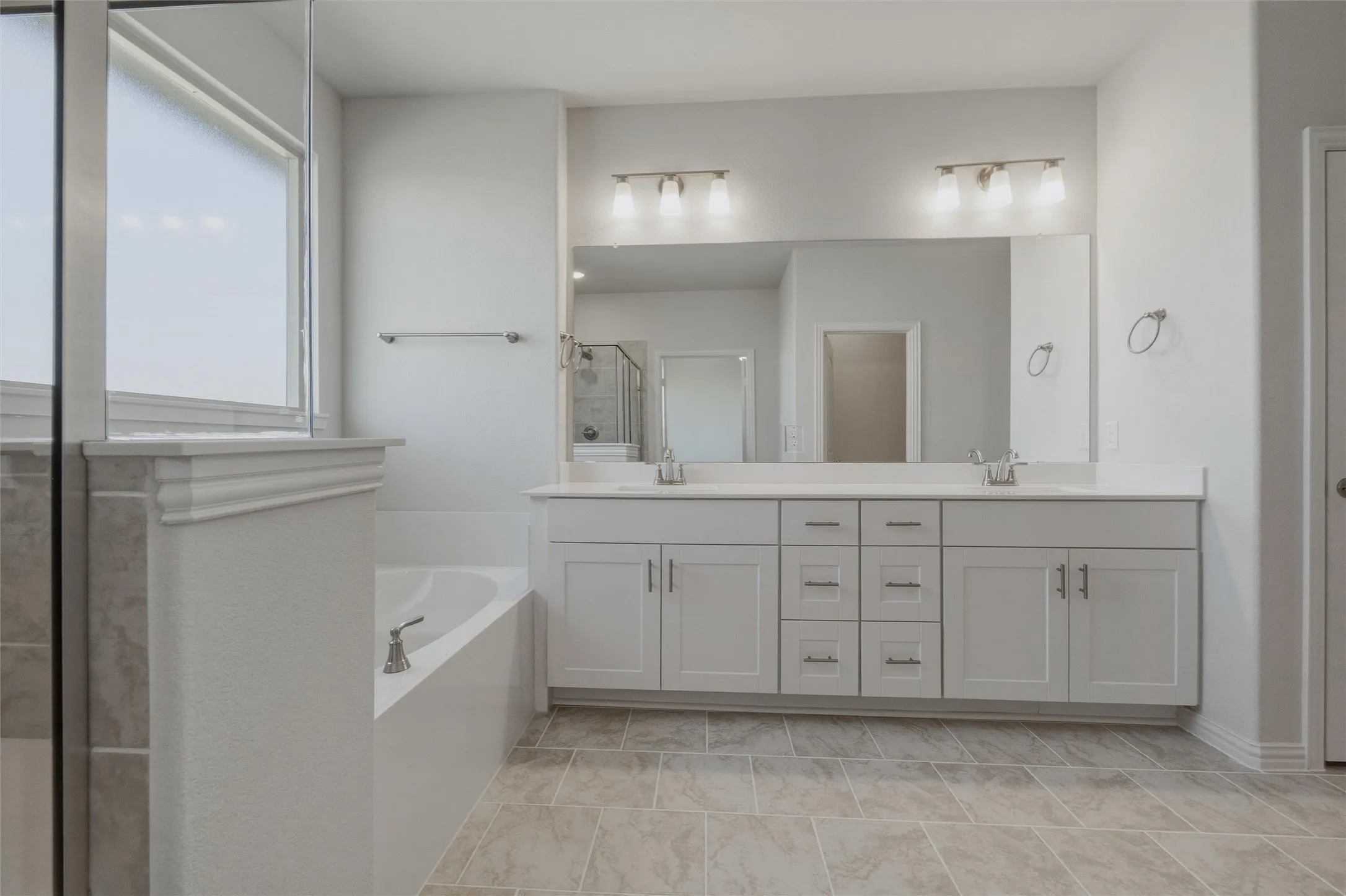 Dual vanity with undermount sinks, light-toned cabinetry, and extensive counter space