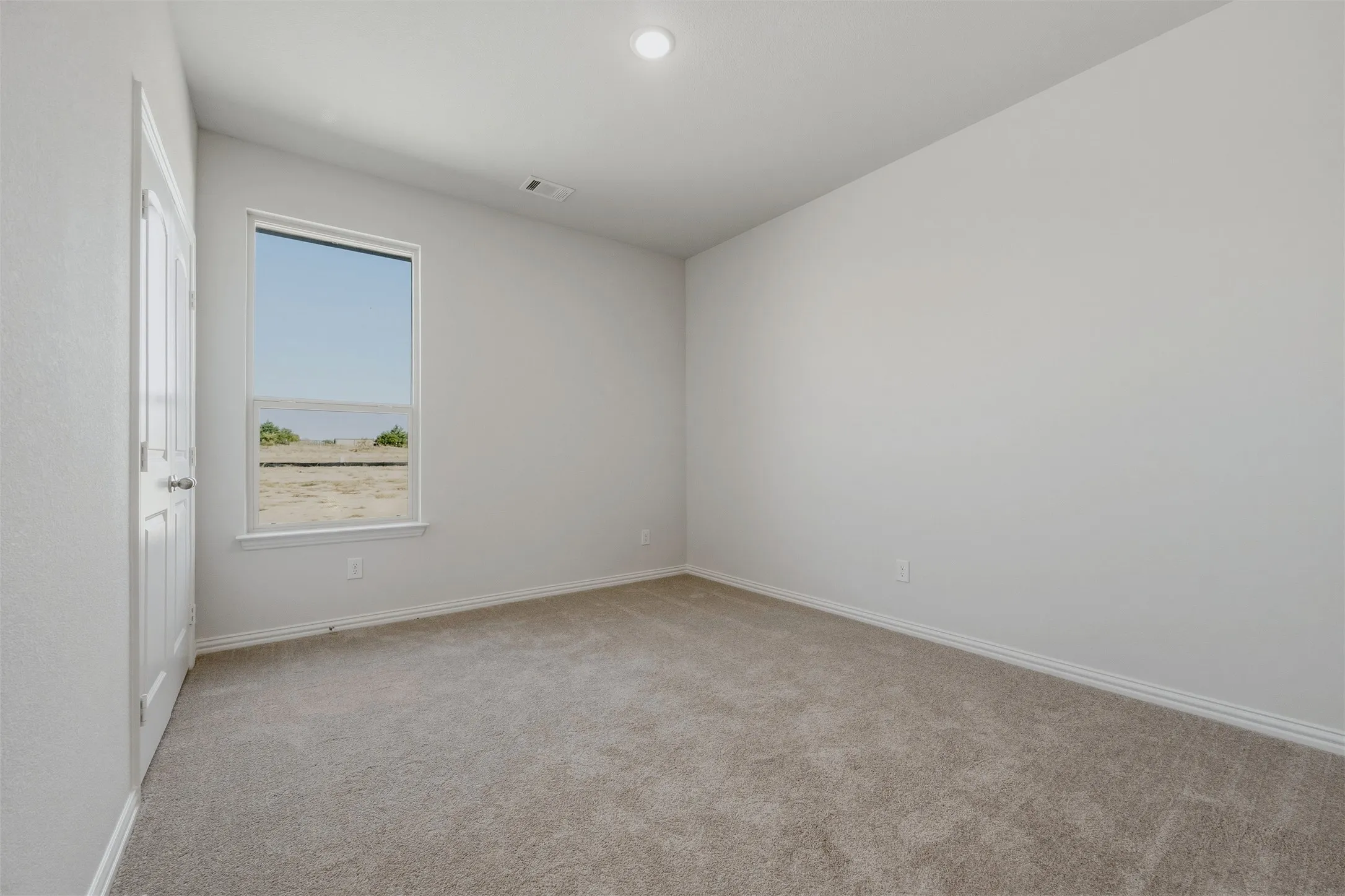 Neutral wall tones, recessed ceiling lighting, and soft carpeting