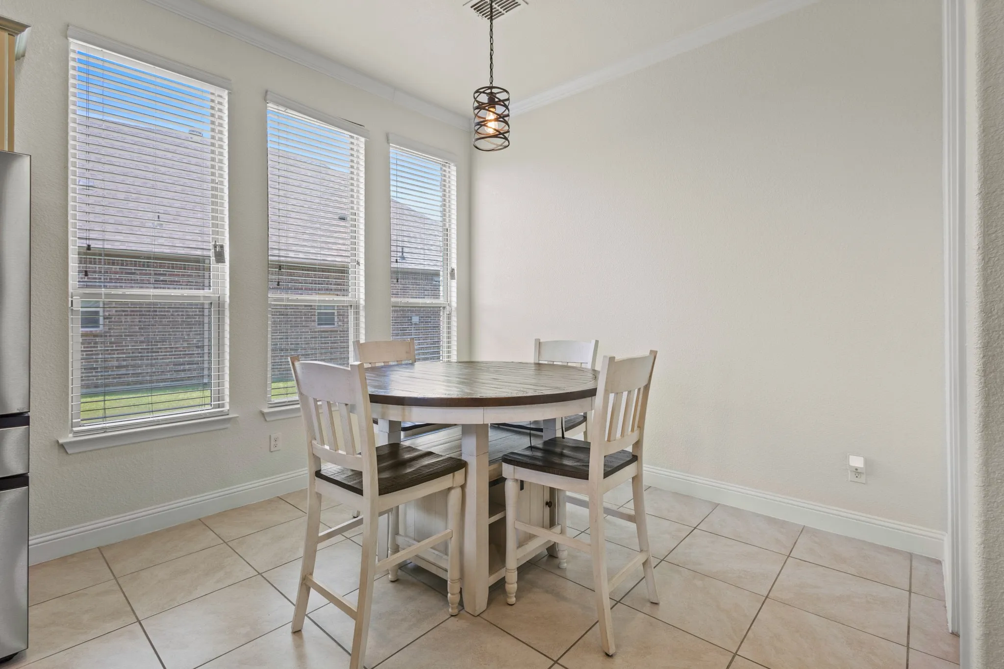 Dining area featuring crown molding, plenty of natural light, baseboards, and light tile patterned flooring