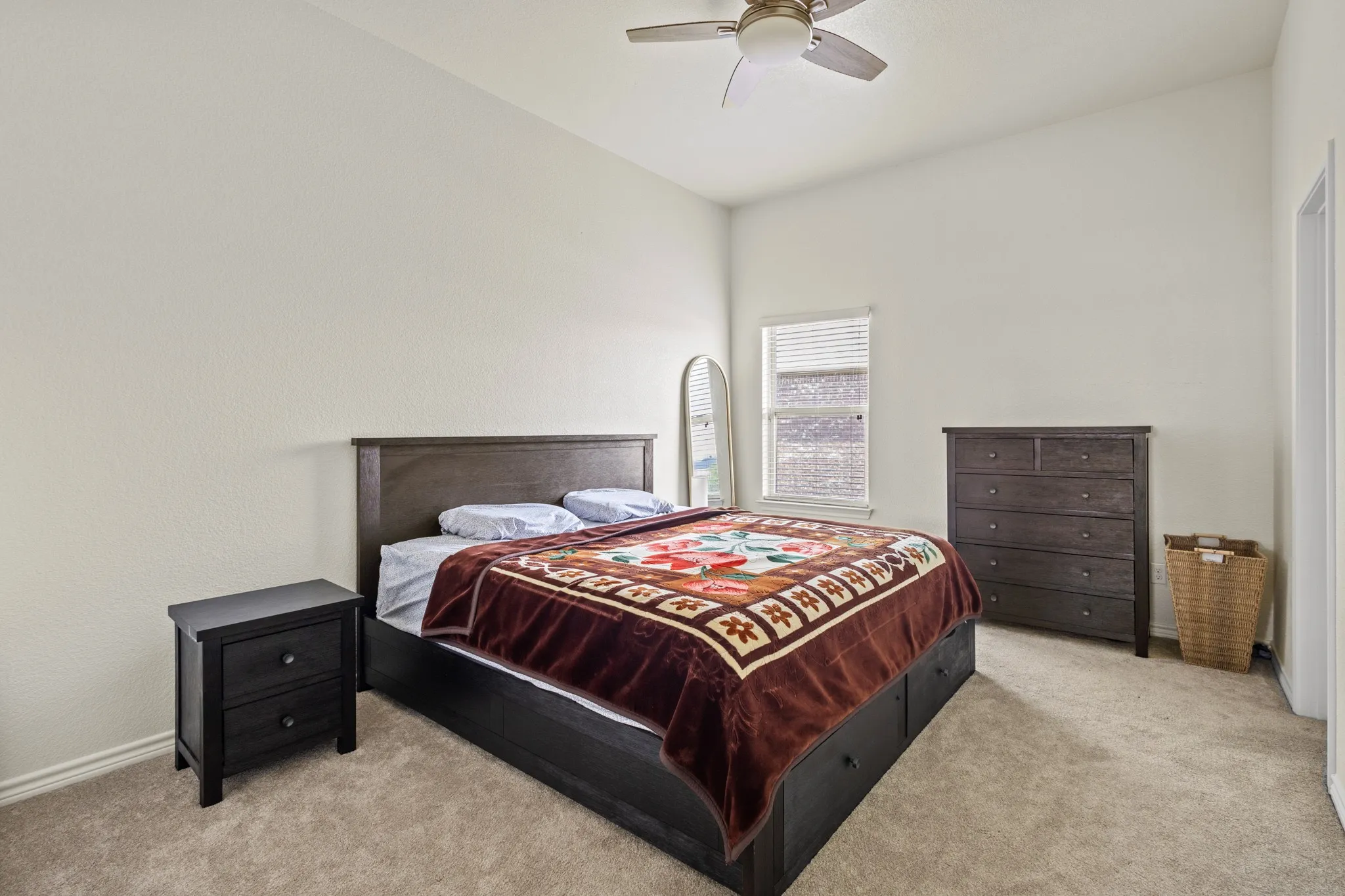 Carpeted bedroom featuring baseboards and a ceiling fan