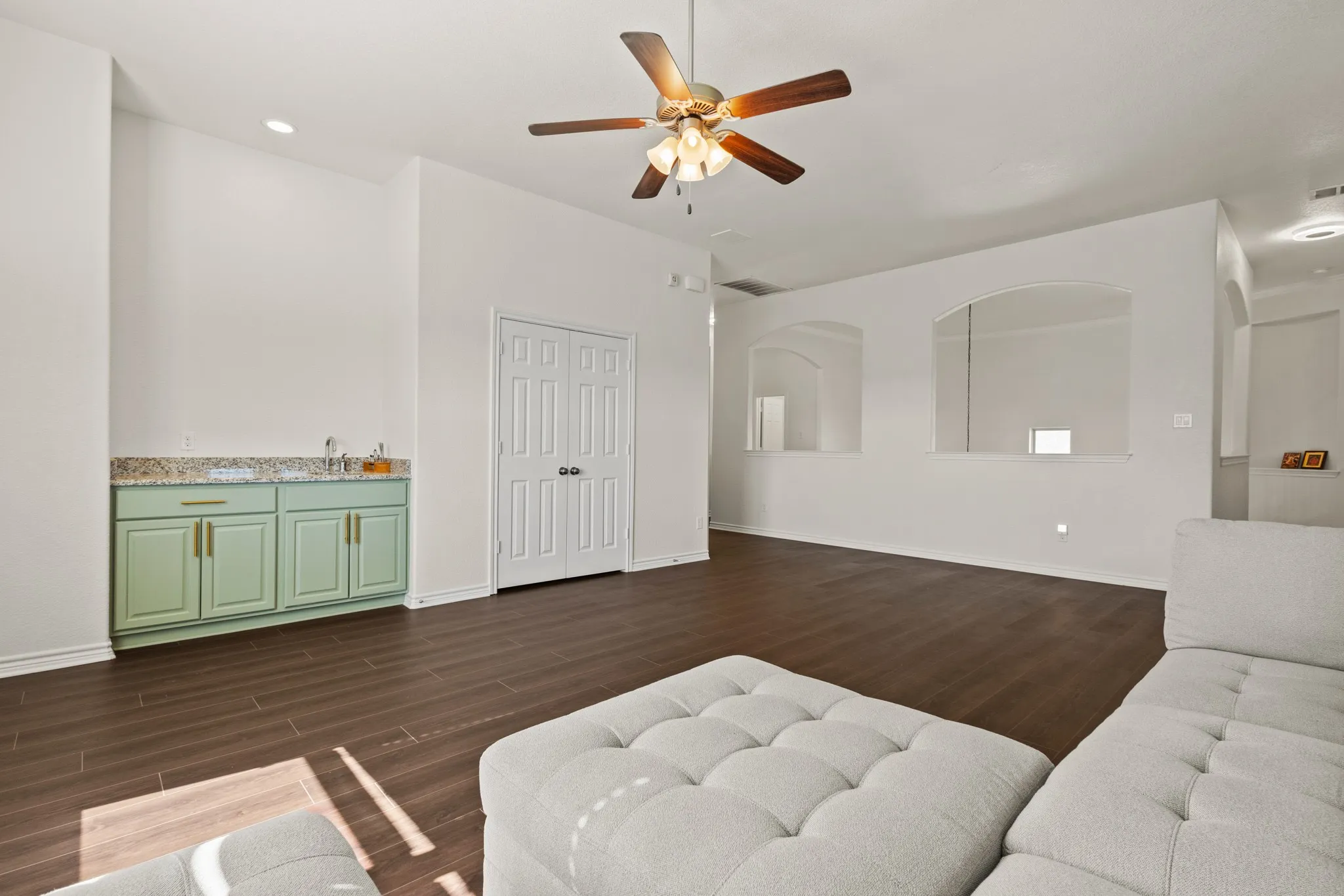 Living area featuring dark wood finished floors, a ceiling fan, and baseboards