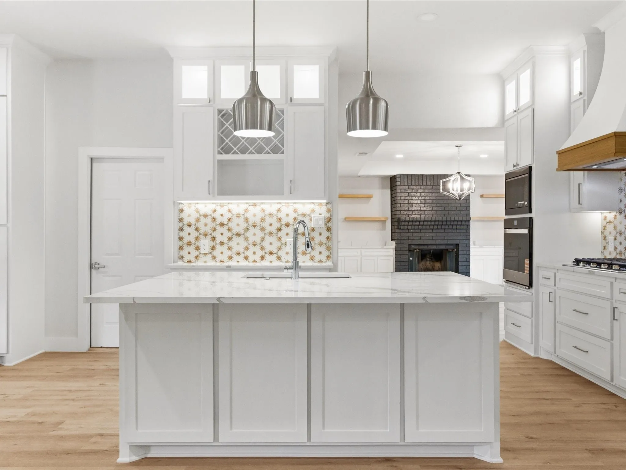 Kitchen featuring white cabinets, pendant lighting, and light stone countertops
