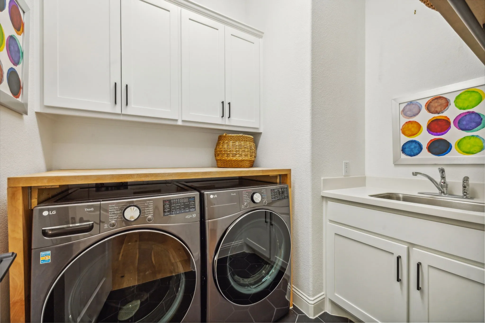 Laundry area with washer and dryer, cabinets, and sink