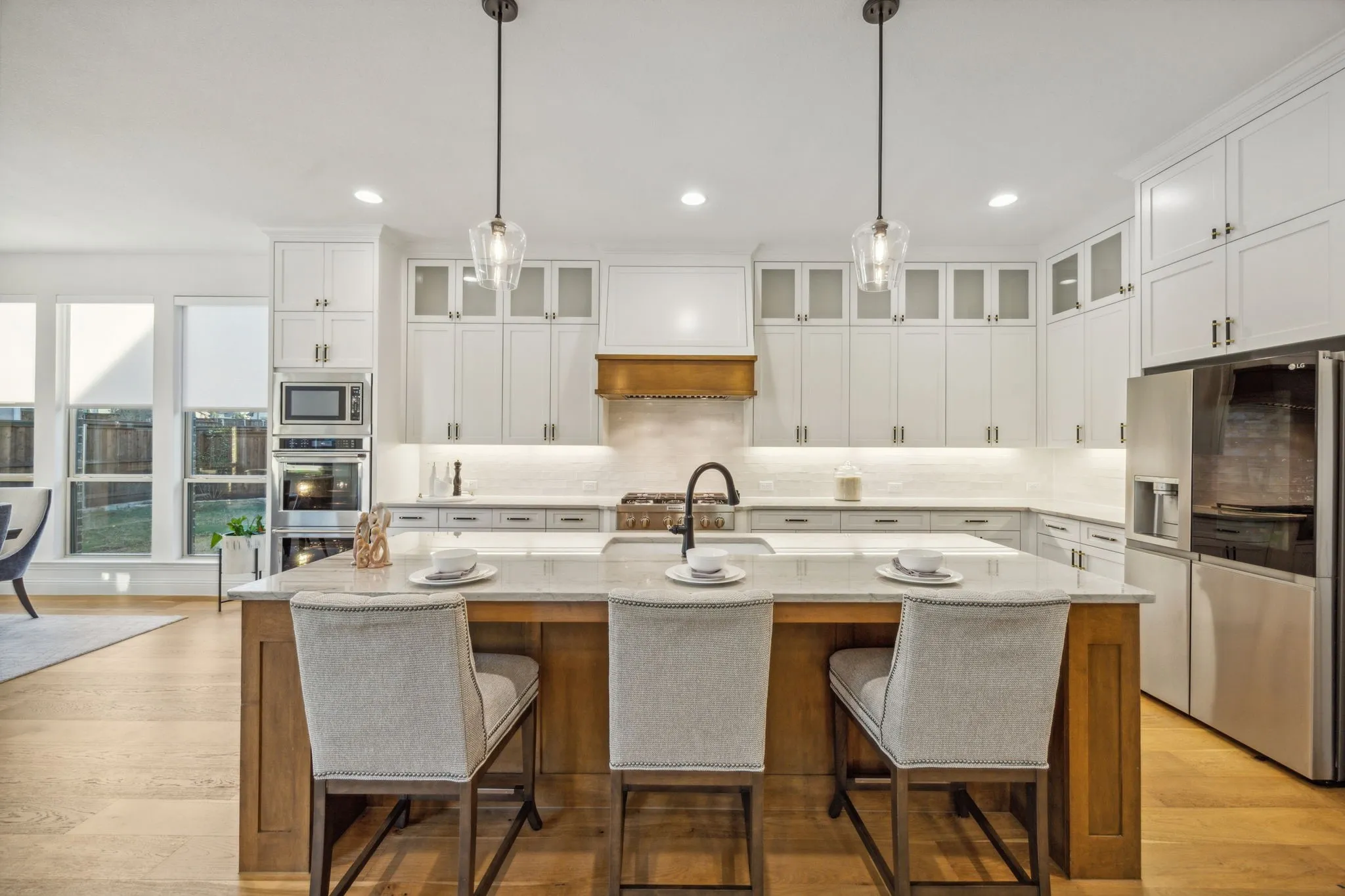 Kitchen with pendant lighting, a kitchen island with sink, and appliances with stainless steel finishes