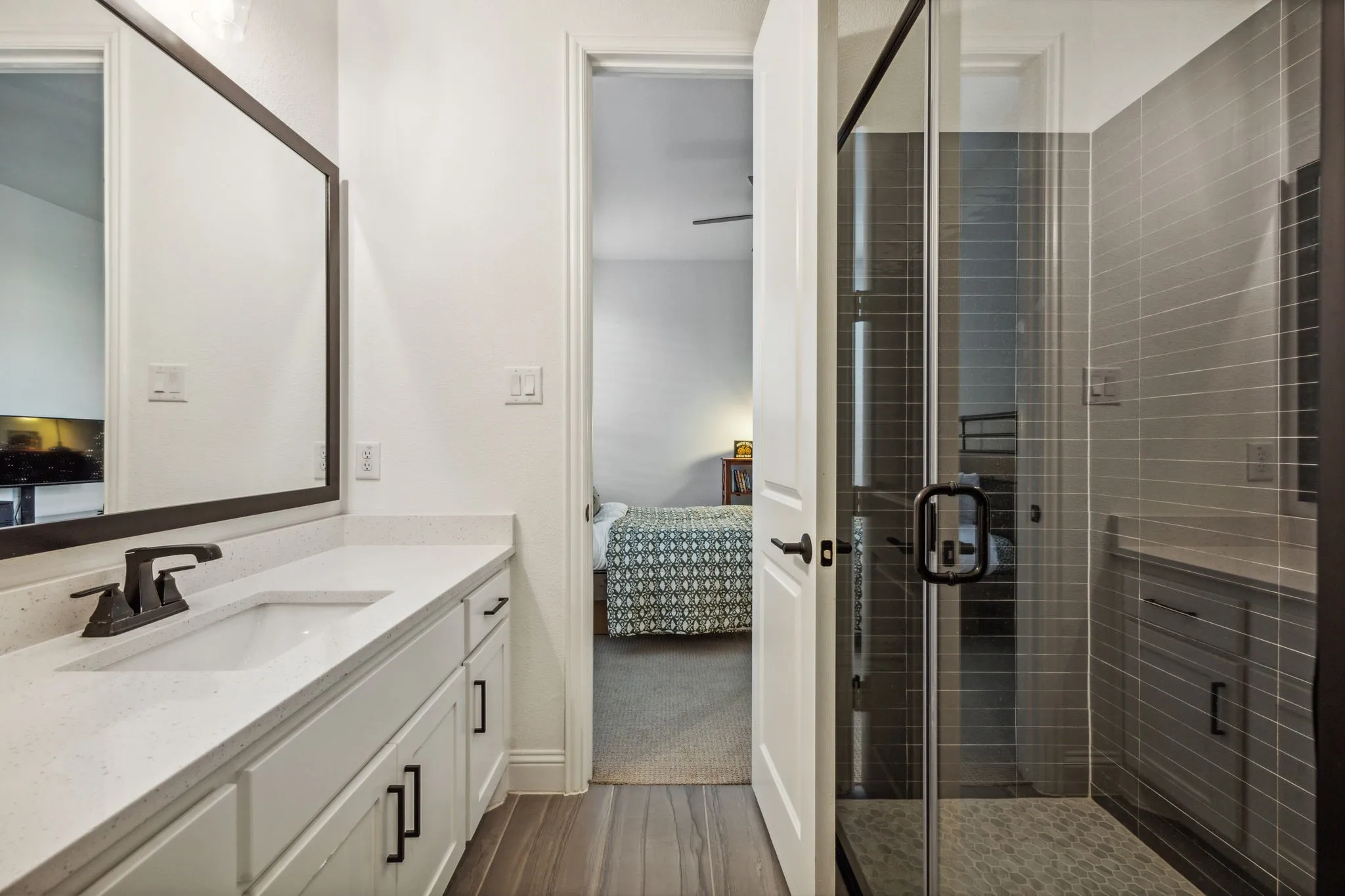 Bathroom featuring vanity, hardwood / wood-style flooring, and a shower with door