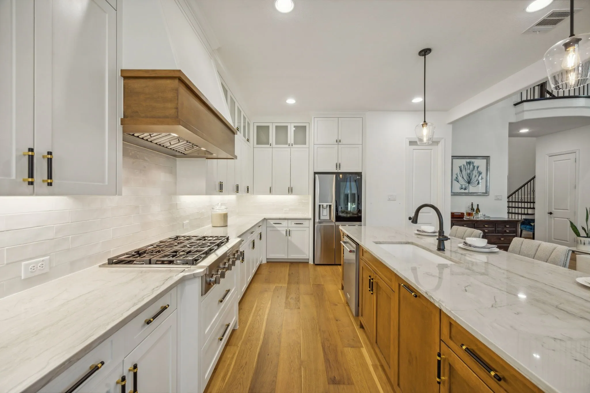 Kitchen with white cabinetry, sink, stainless steel appliances, and light stone counters