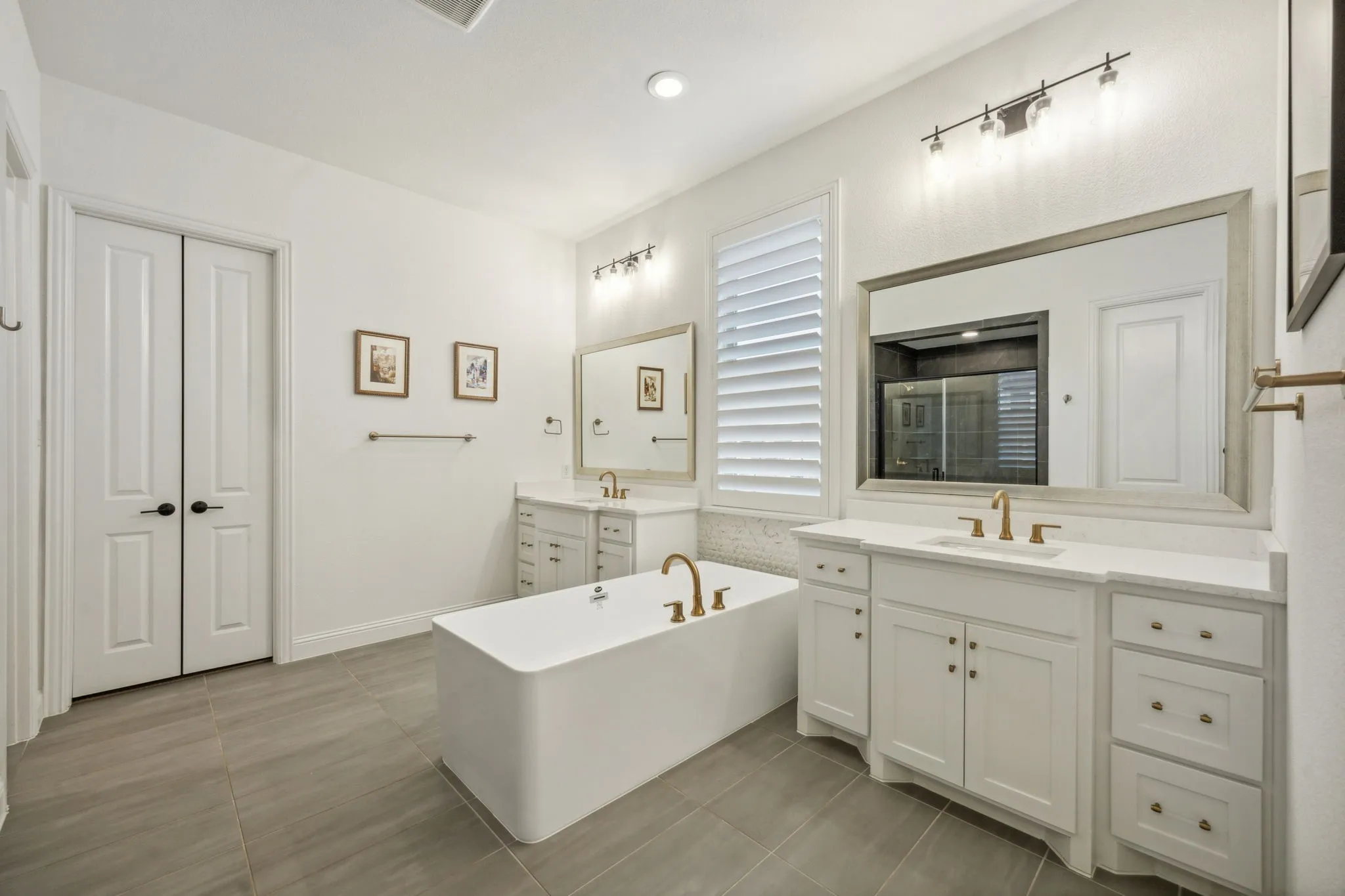 Bathroom featuring tile patterned flooring, vanity, and a tub