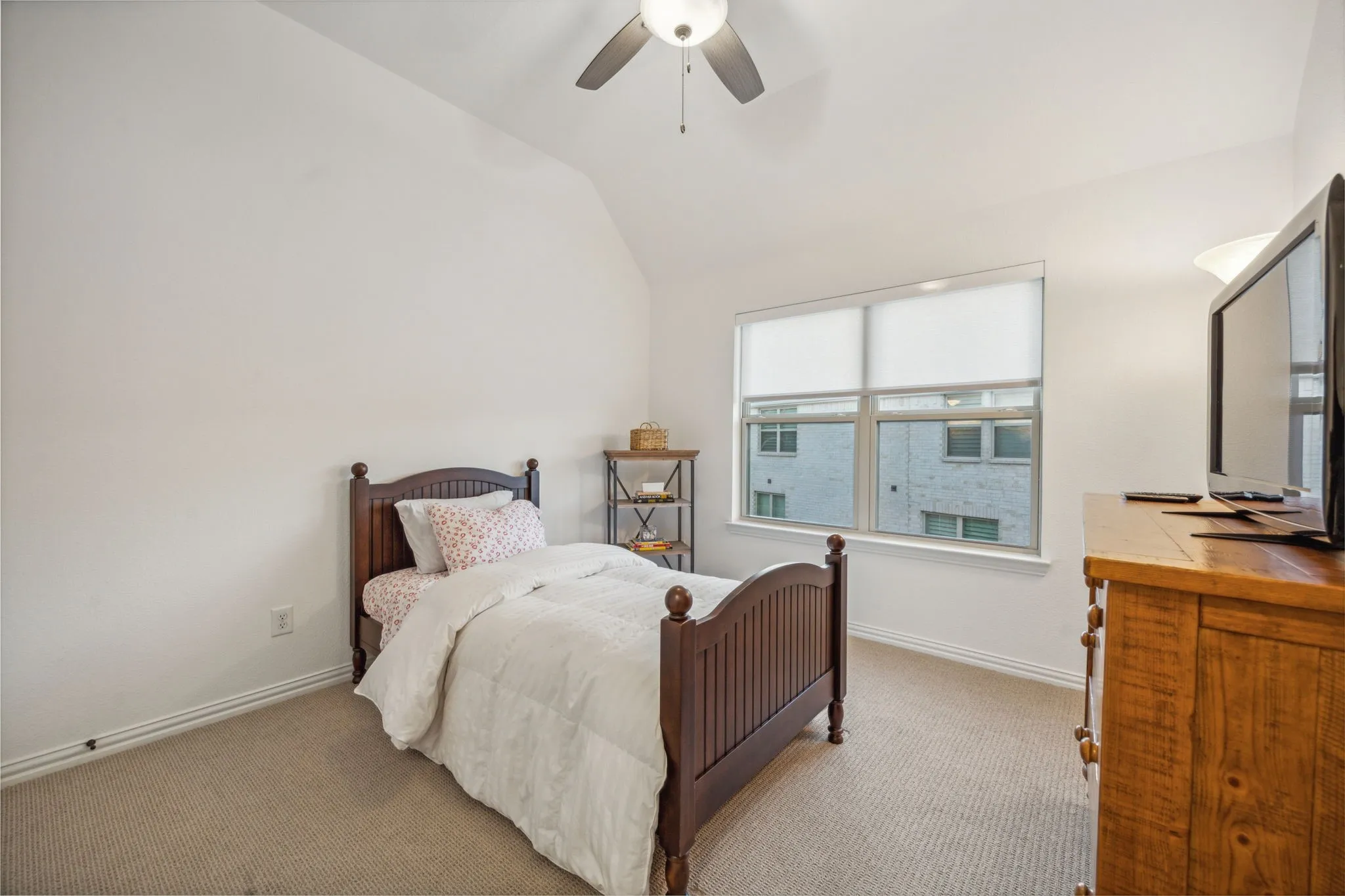 Bedroom featuring ceiling fan, light carpet, and vaulted ceiling