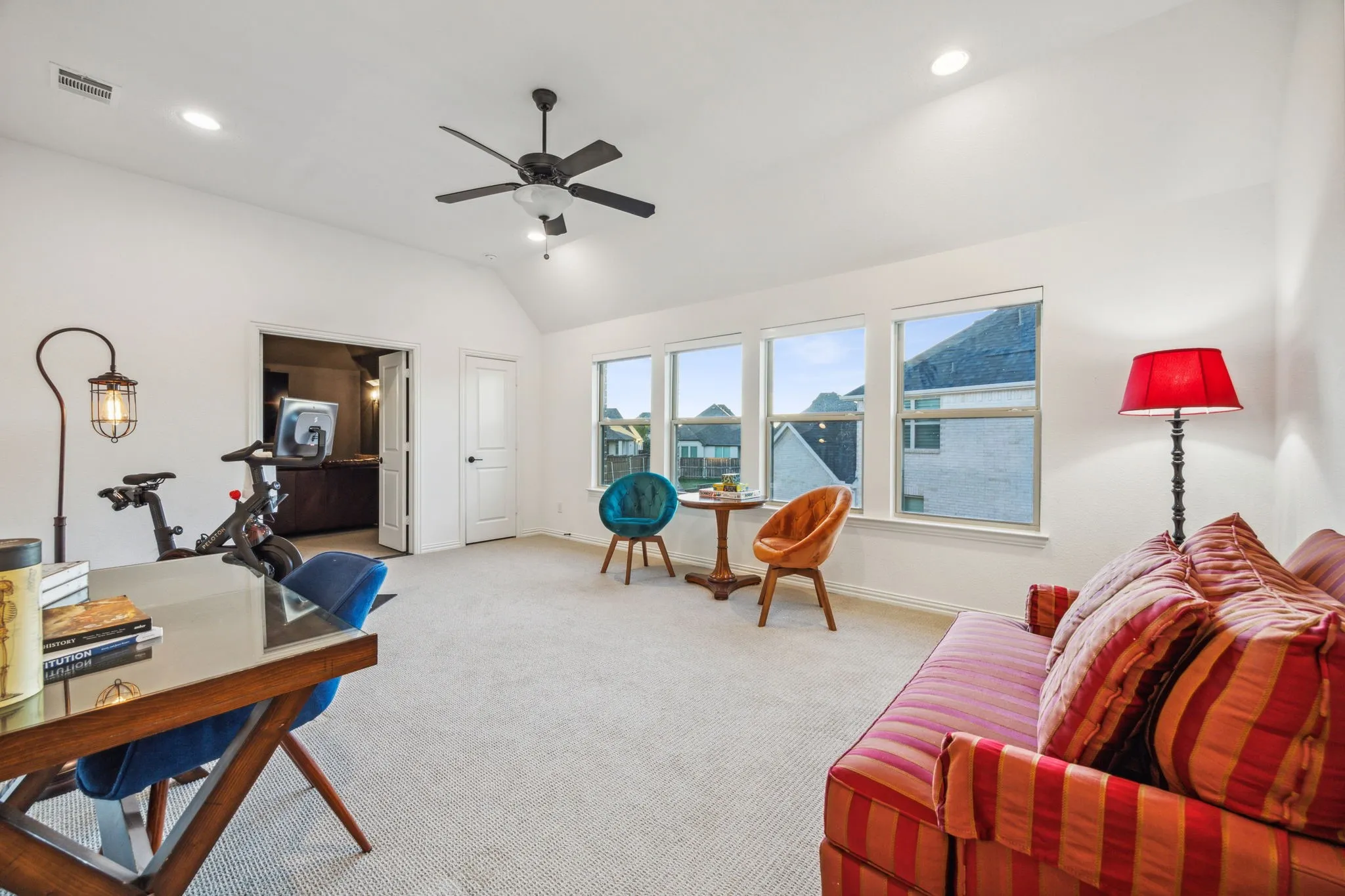 Carpeted office with ceiling fan and lofted ceiling
