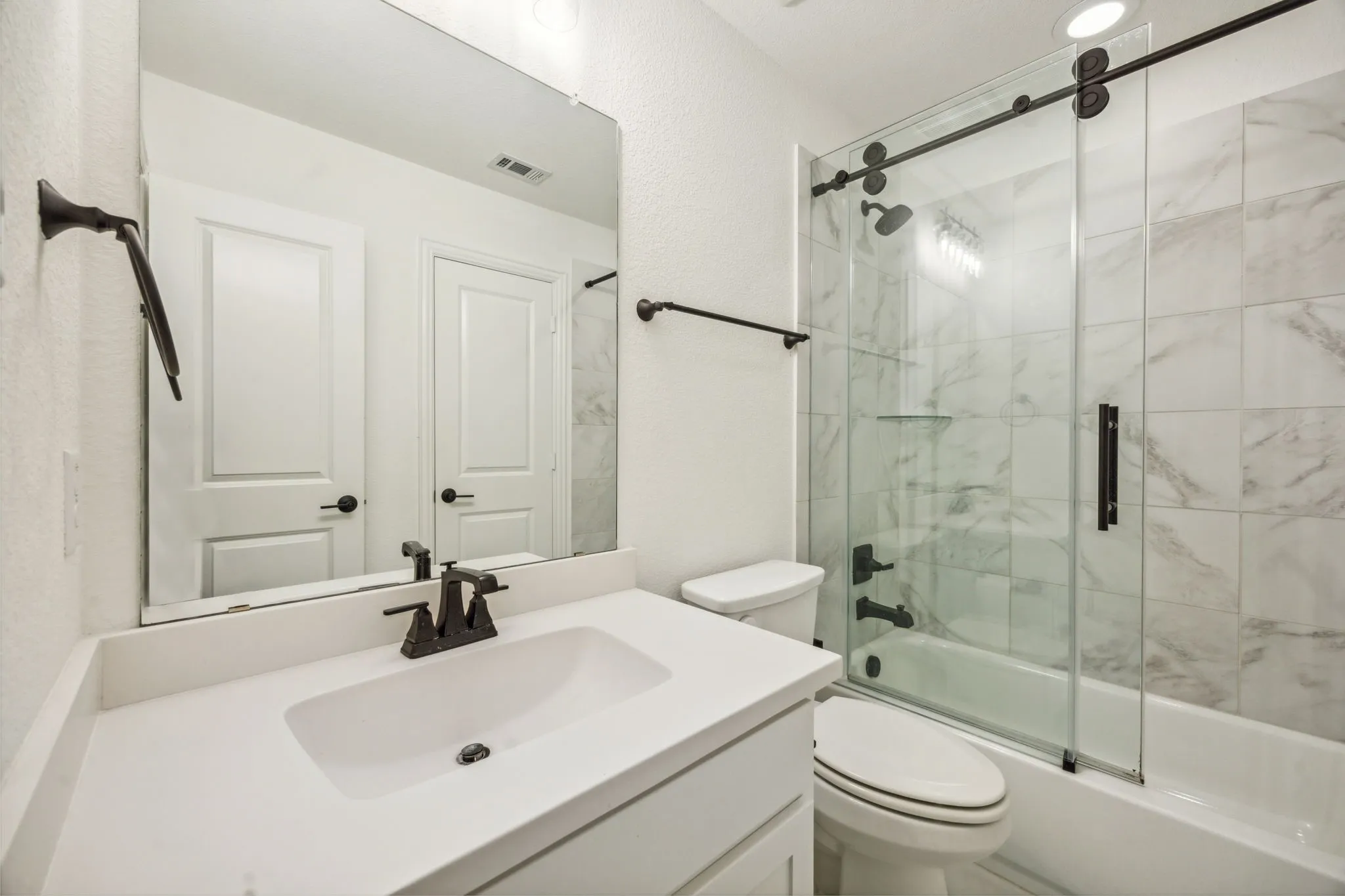 Full bathroom featuring vanity, enclosed tub / shower combo, and toilet