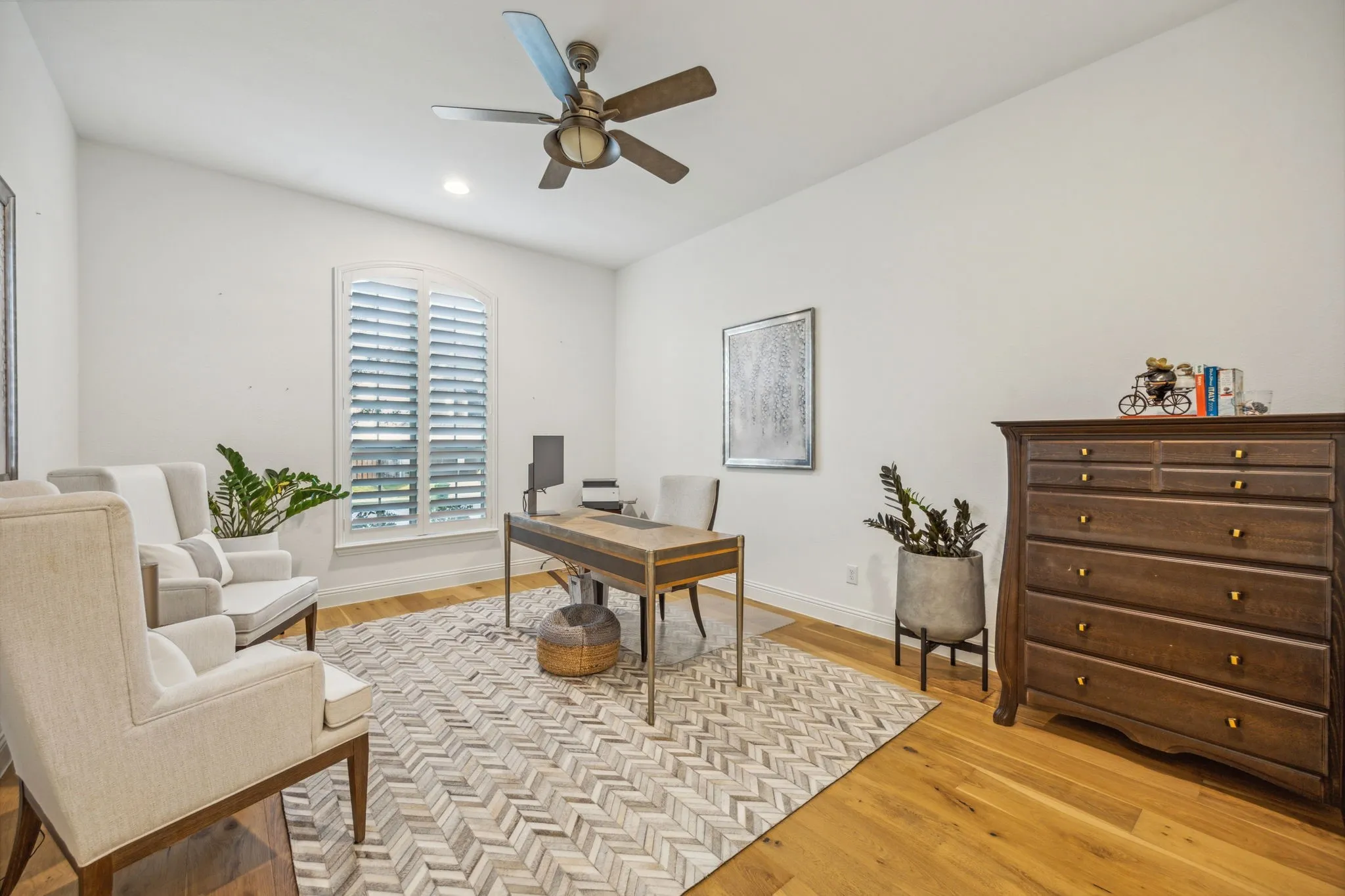 Office area with ceiling fan and light hardwood / wood-style floors