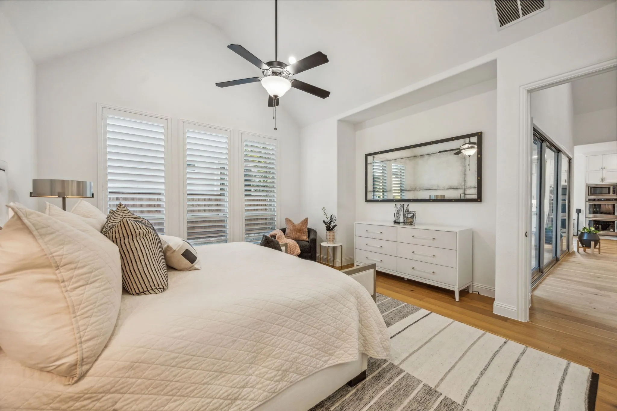 Bedroom with access to exterior, ceiling fan, light hardwood / wood-style flooring, and vaulted ceiling