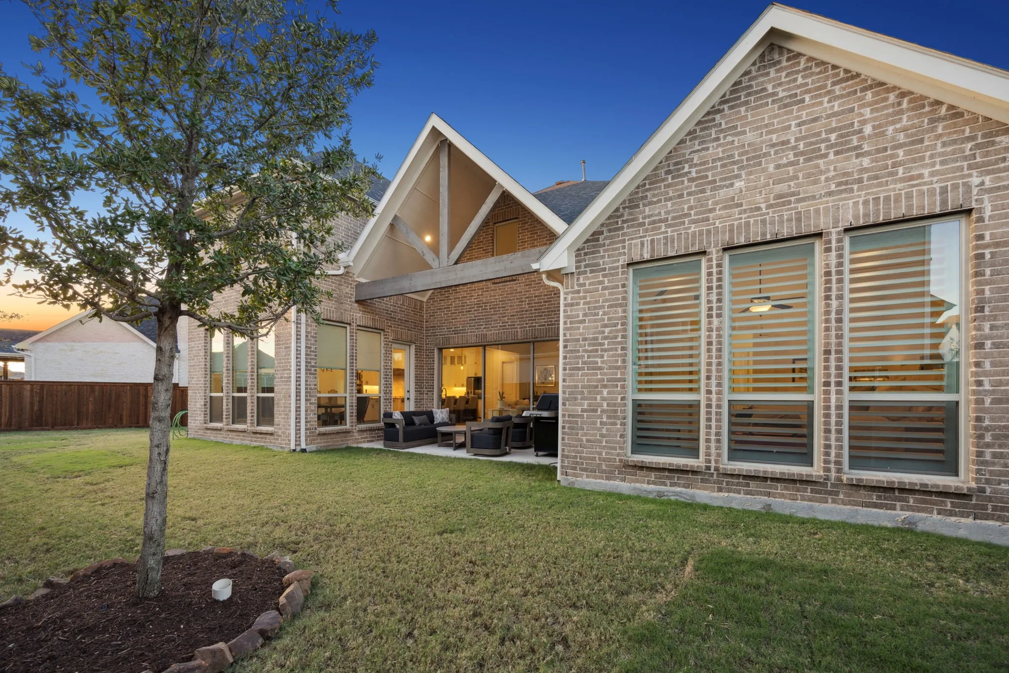 Back house at dusk with a yard, an outdoor hangout area, and a patio area