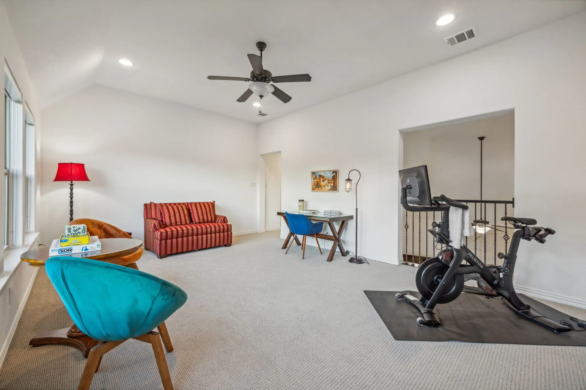 Exercise room featuring ceiling fan, carpet, and lofted ceiling