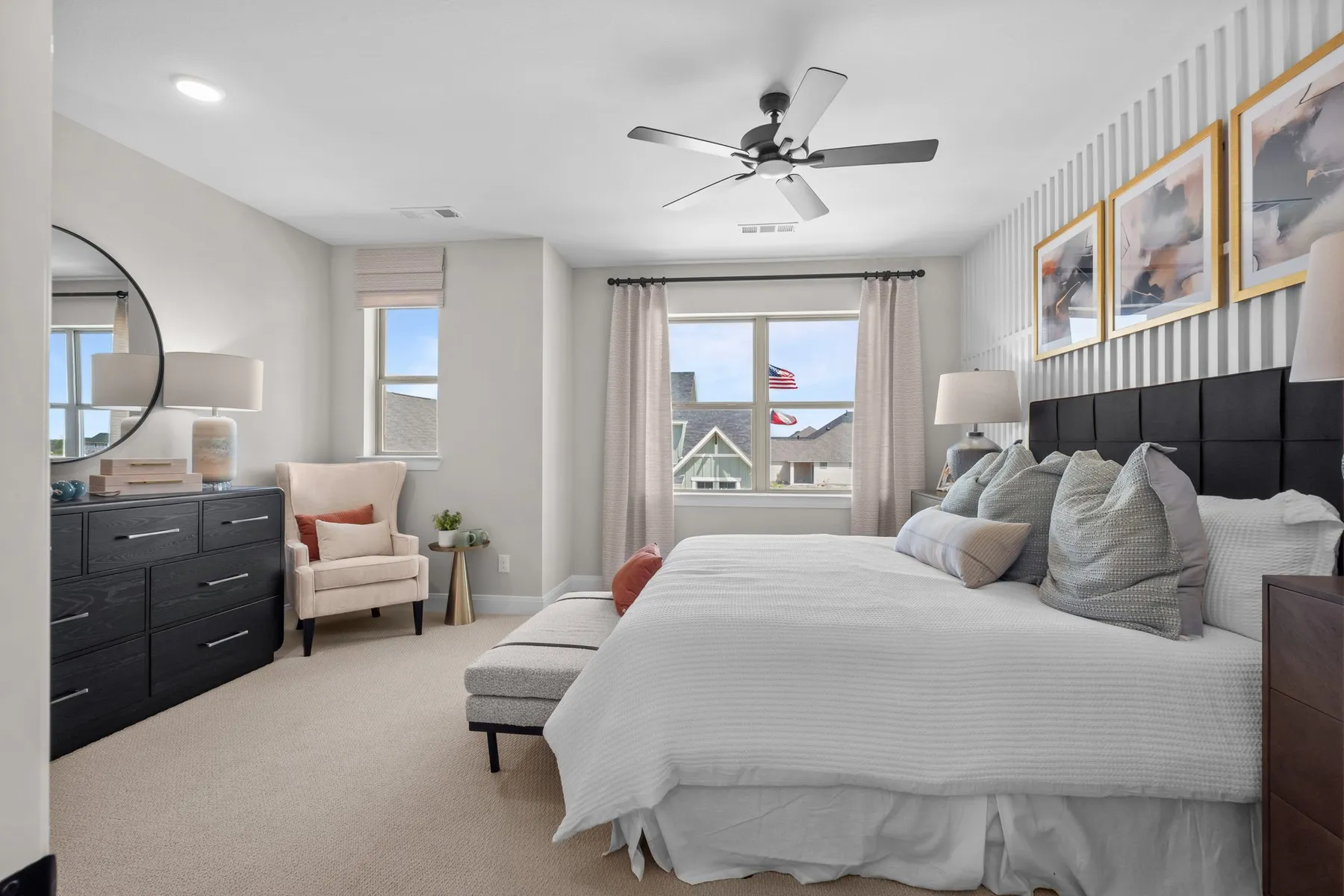 Bedroom with a ceiling fan, wallpapered walls, and light carpet