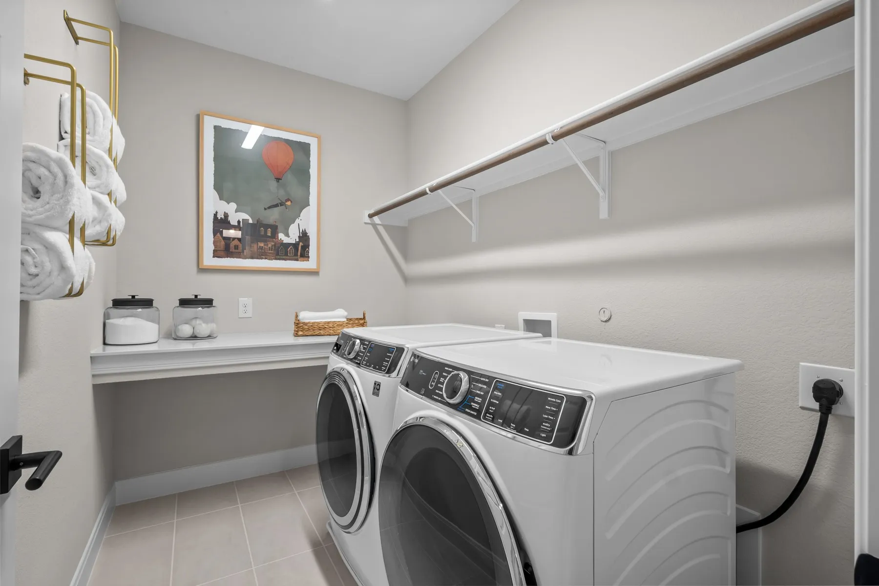 Laundry area featuring independent washer and dryer and light tile patterned floors