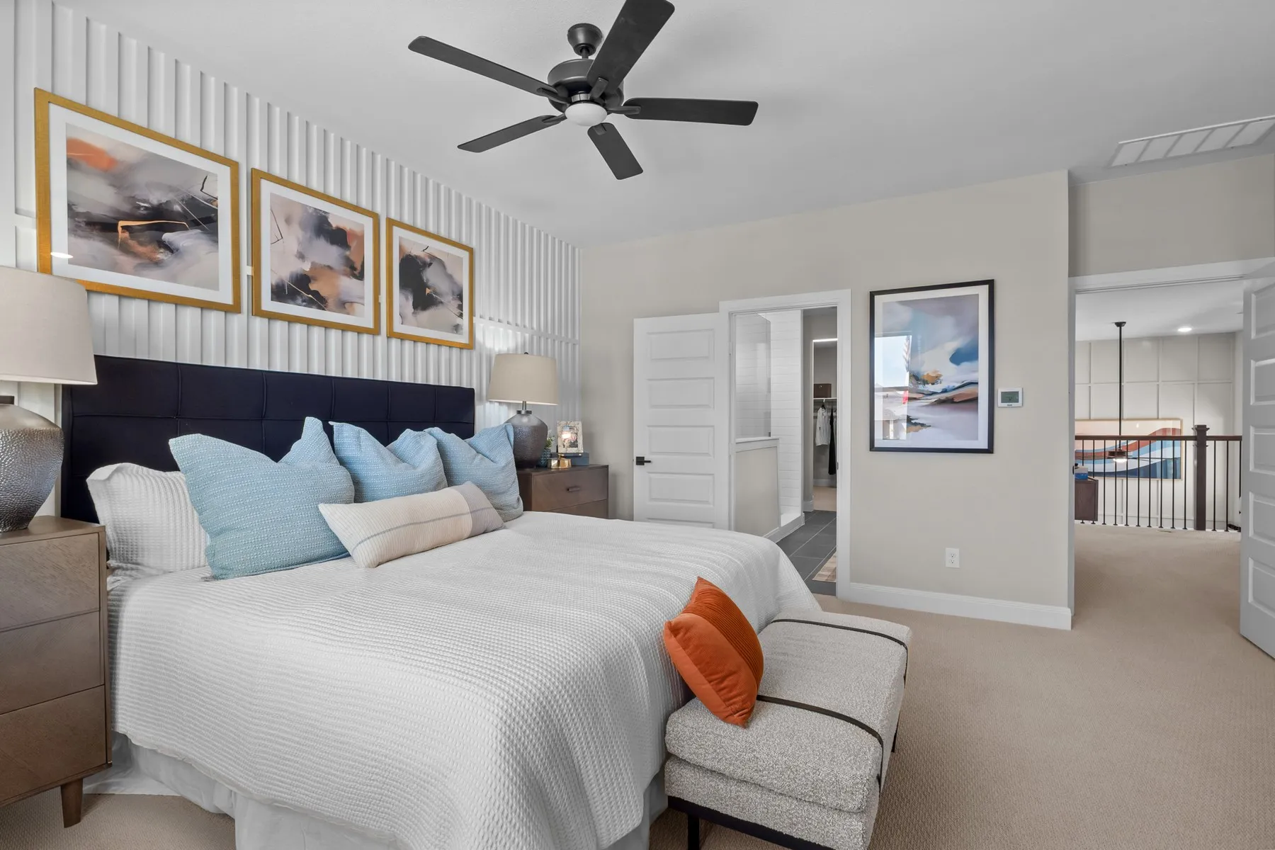 Bedroom featuring wallpapered walls, carpet flooring, ensuite bath, and a ceiling fan