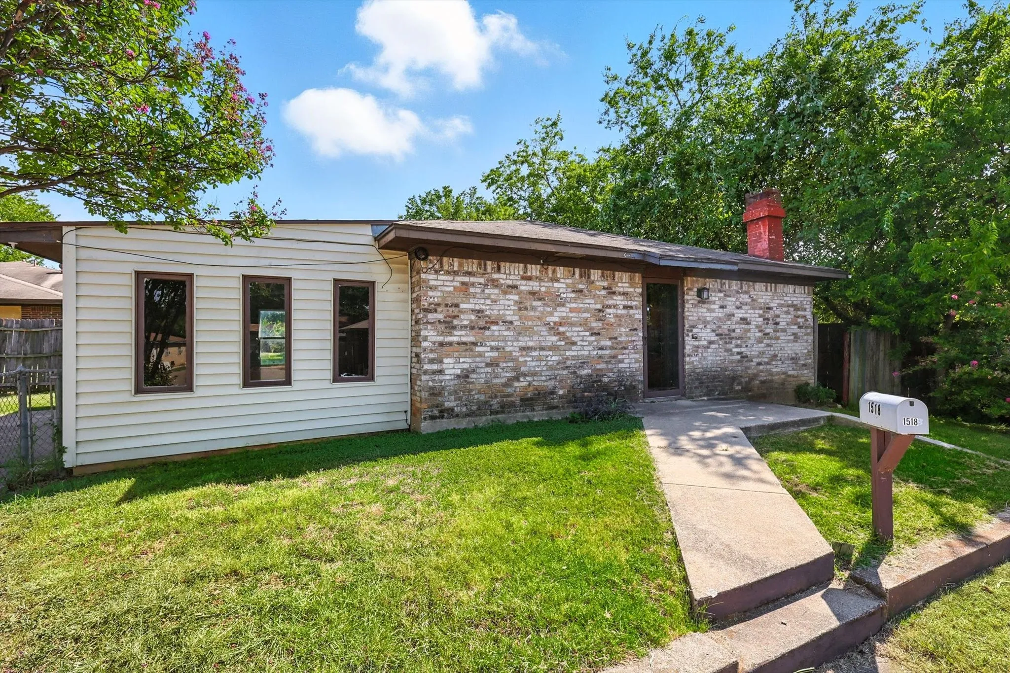View of front of house with brick siding and a chimney