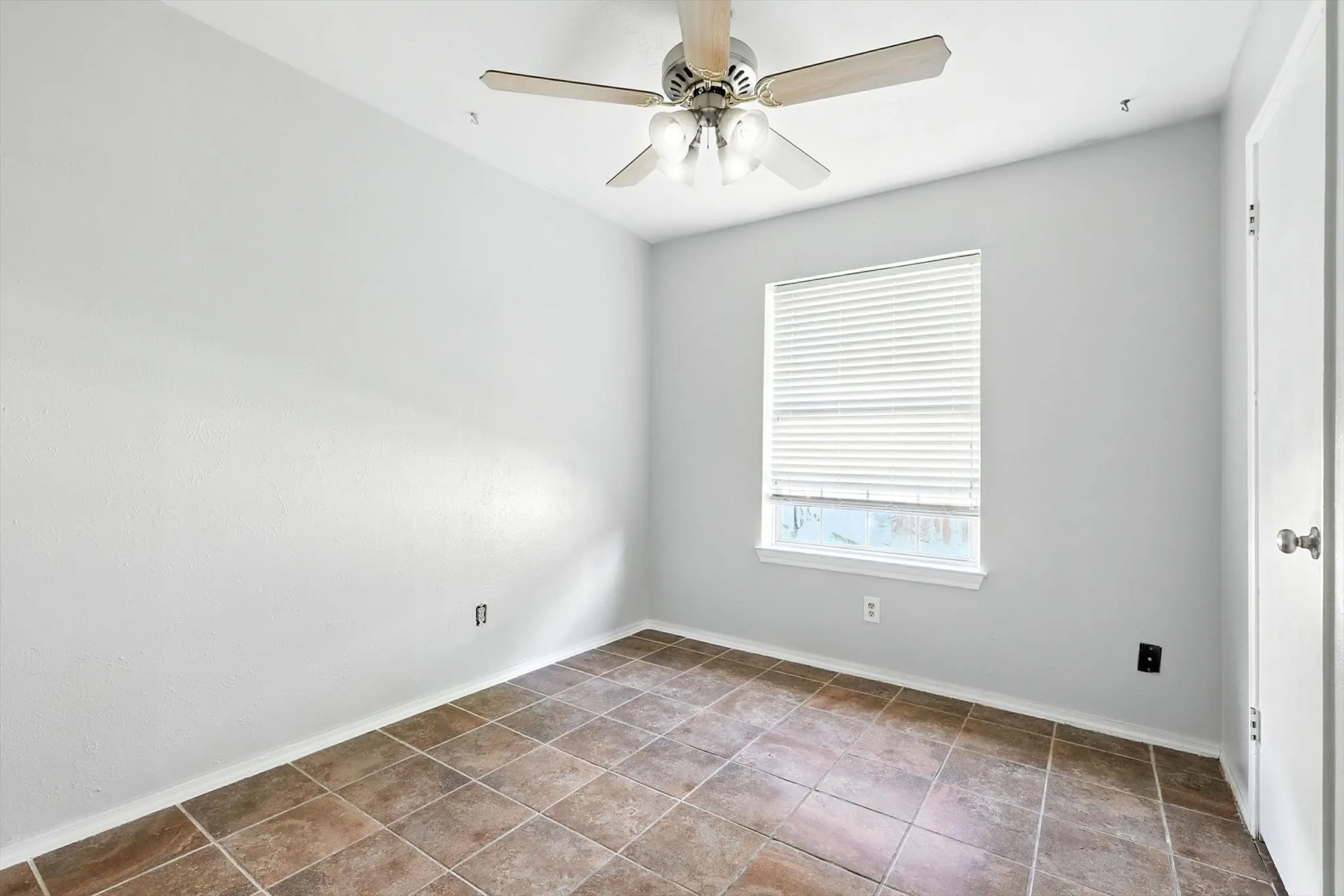 Spare room featuring ceiling fan and tile patterned flooring