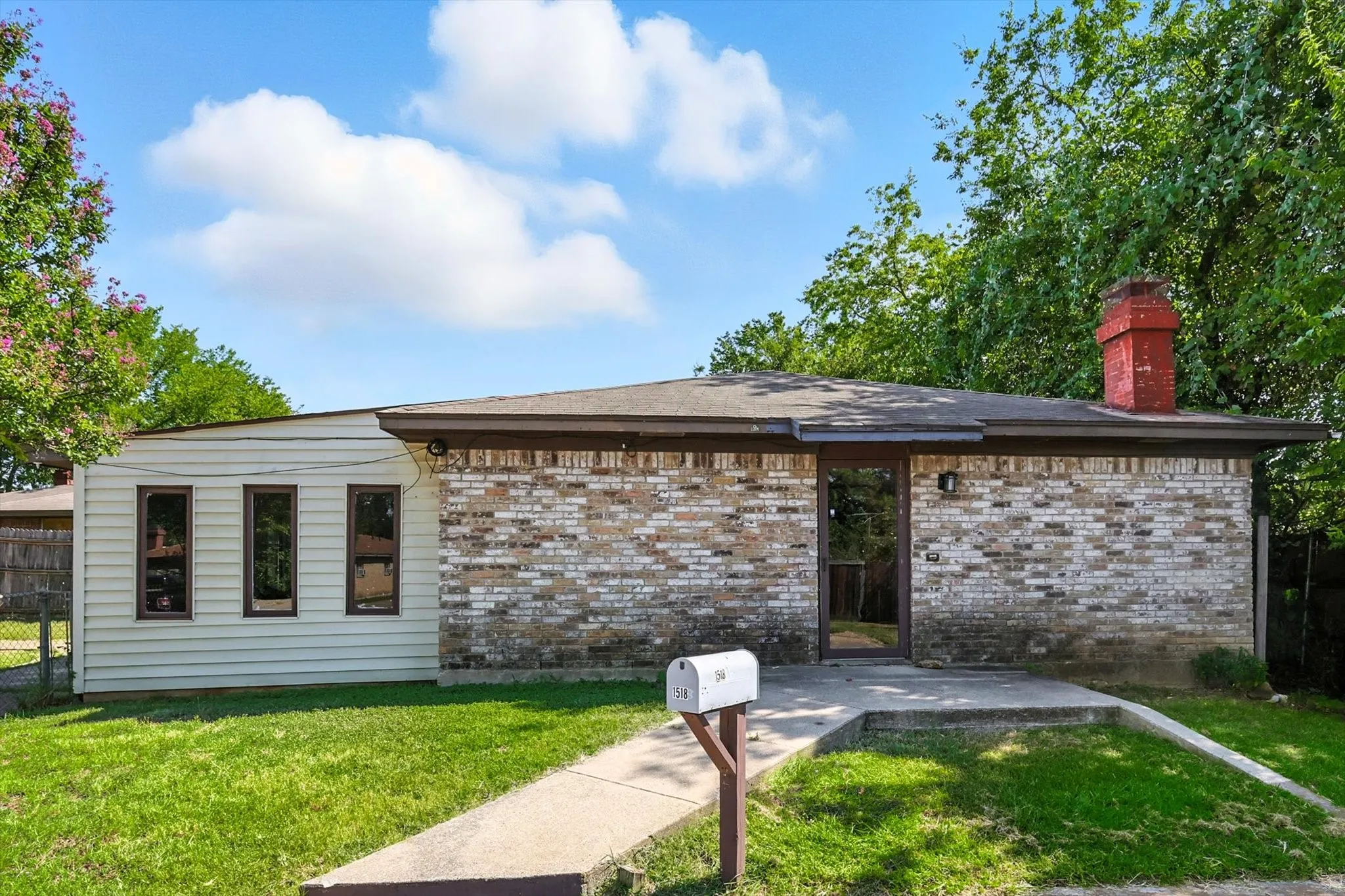 Back of property with brick siding, a patio area, and a chimney