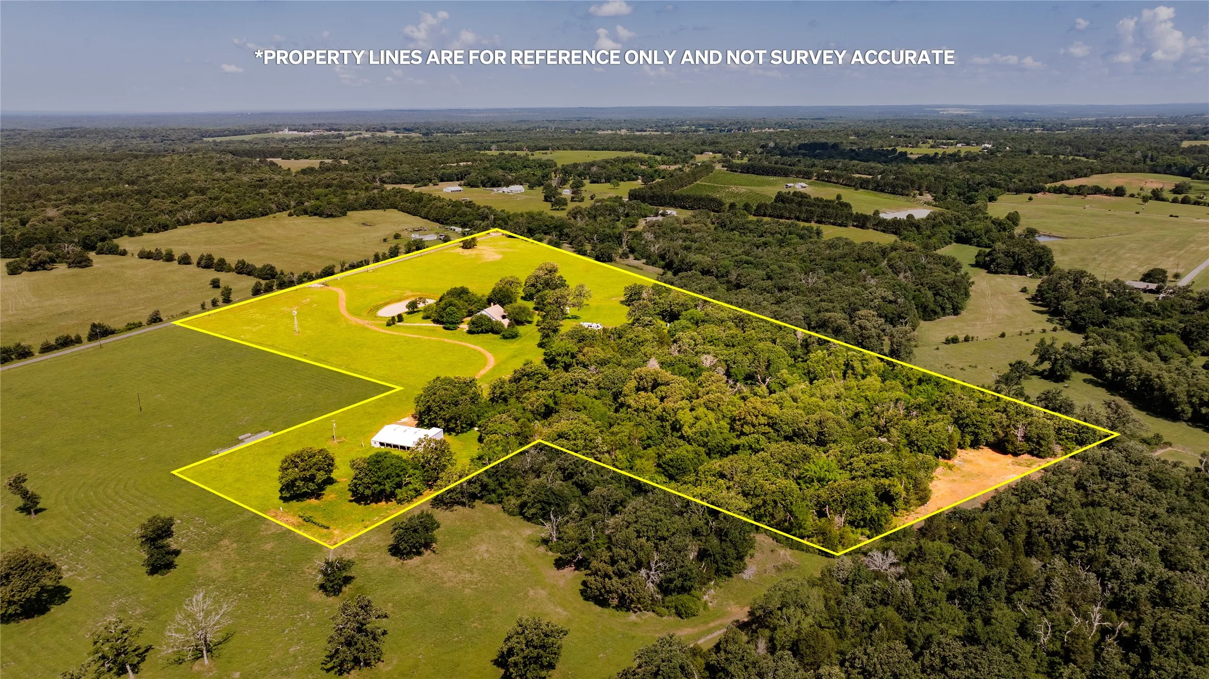Expansive acreage featuring a mix of open fields and mature tree coverage