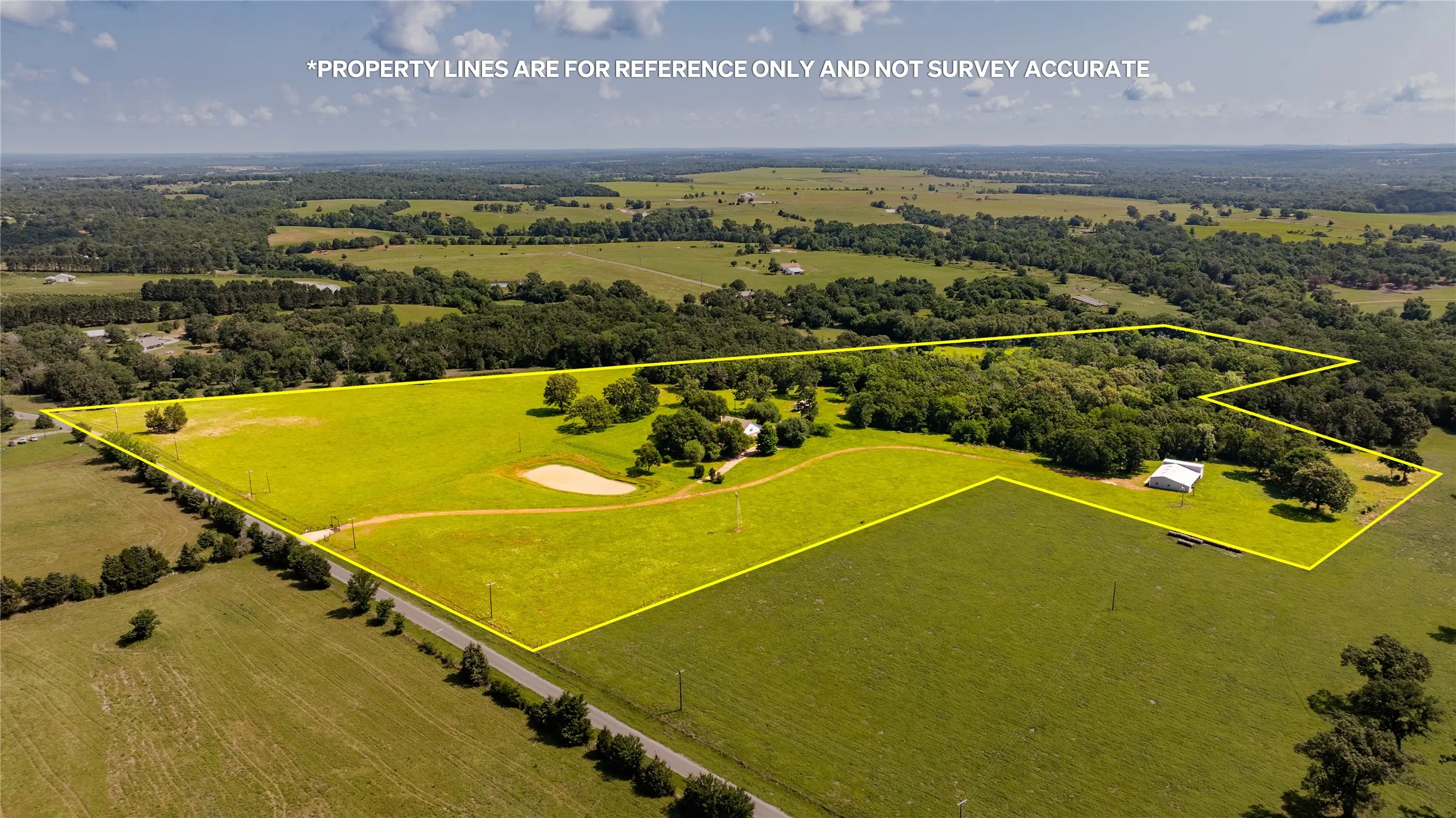 Expansive rural property featuring open fields and wooded areas