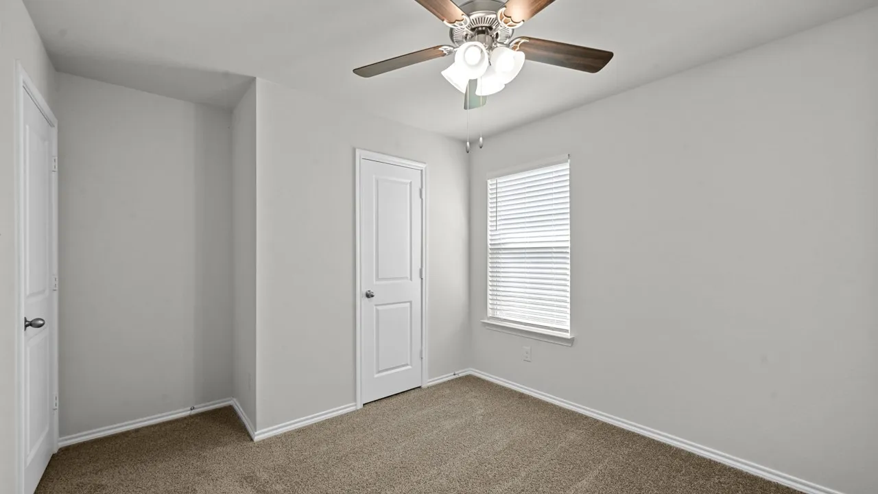 Room featuring light gray walls, carpet flooring, and a ceiling fan with integrated lighting