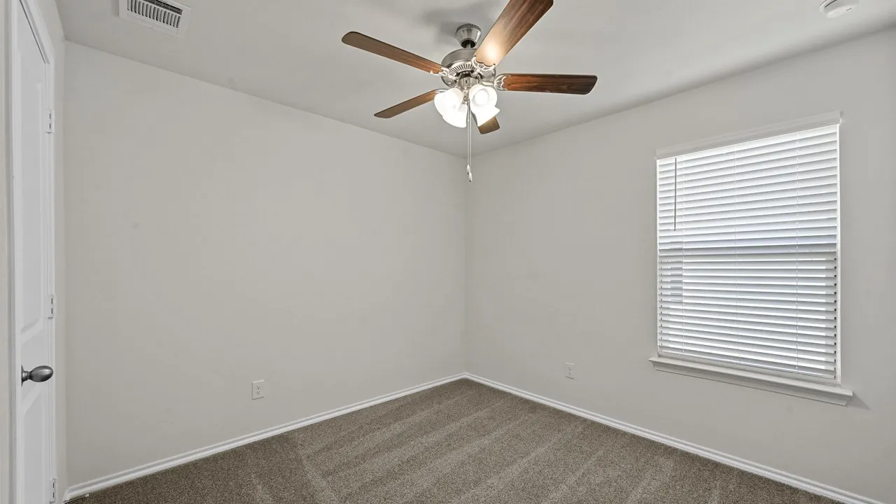 Neutral wall color, carpeted flooring, and a ceiling fan with integrated lighting