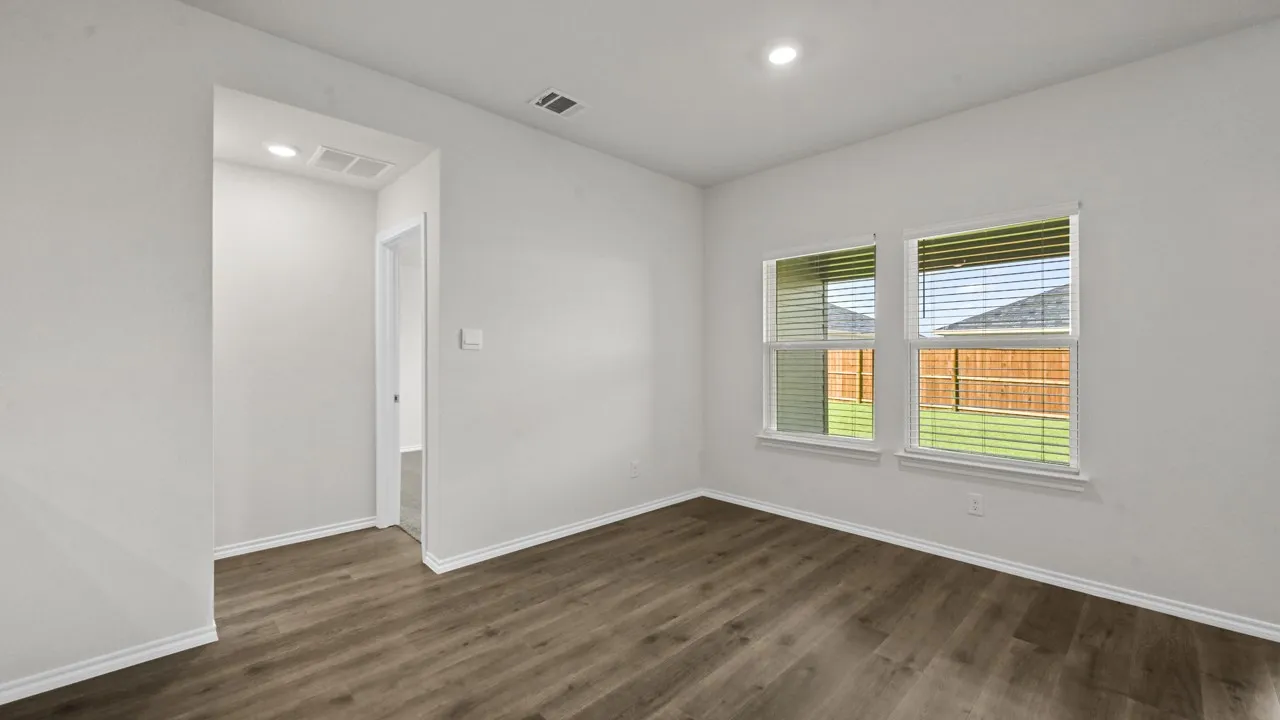 Neutral-toned room featuring two windows with horizontal blinds, wood-finish flooring, white baseboards, and recessed lighting