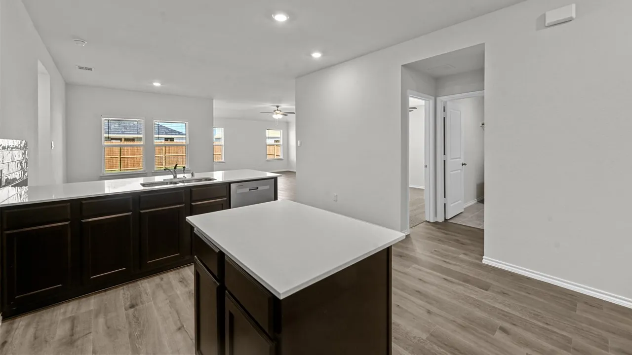 Kitchen with light countertops, a kitchen island, light wood-style floors, dishwasher, and recessed lighting