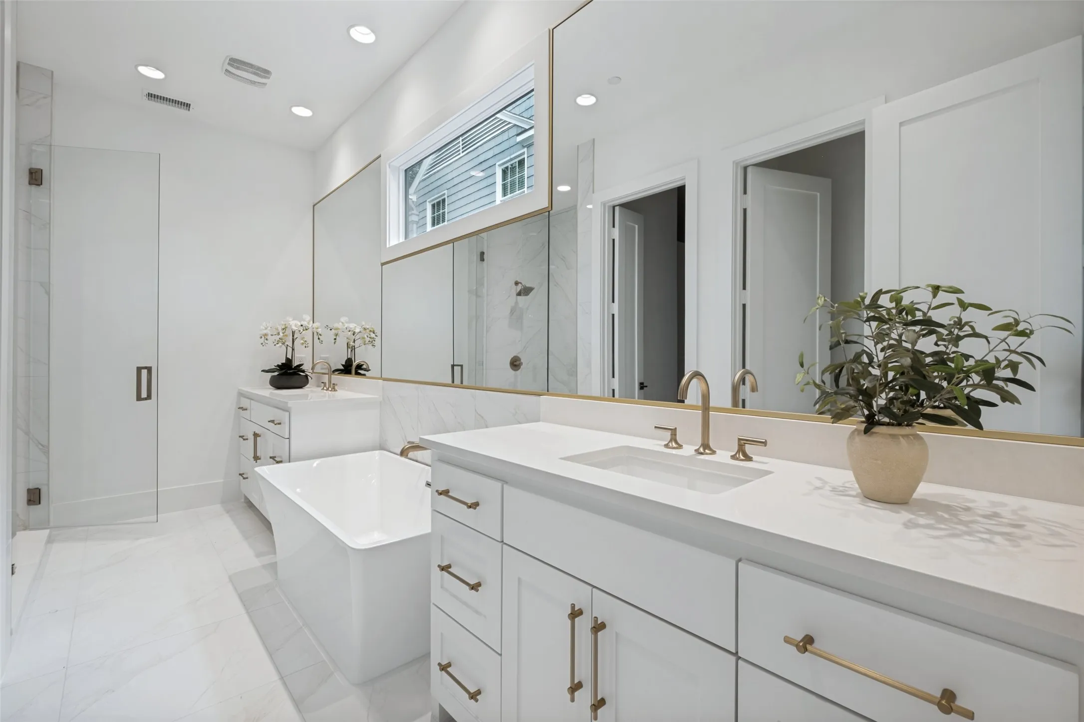 The relaxing primary bathroom features light tile finishes, a generous sized walk-in shower, and a separate soaking tub.