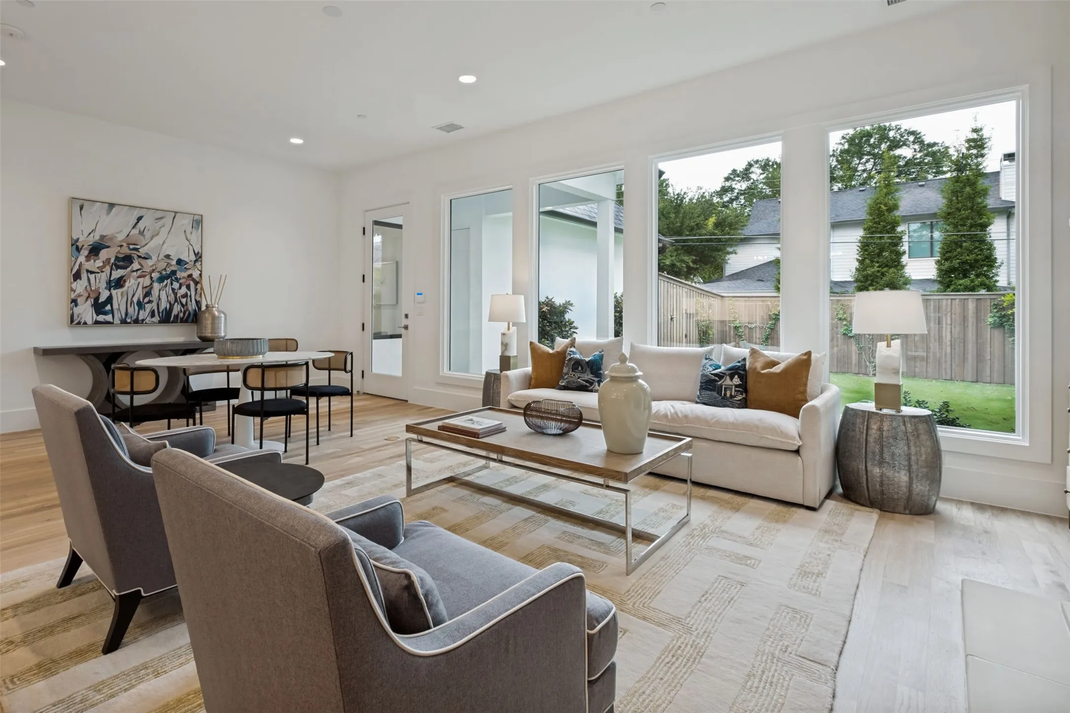 The expansive wall of windows allows abundant natural light with views of the pool sized landscaped yard with an 8' privacy fence