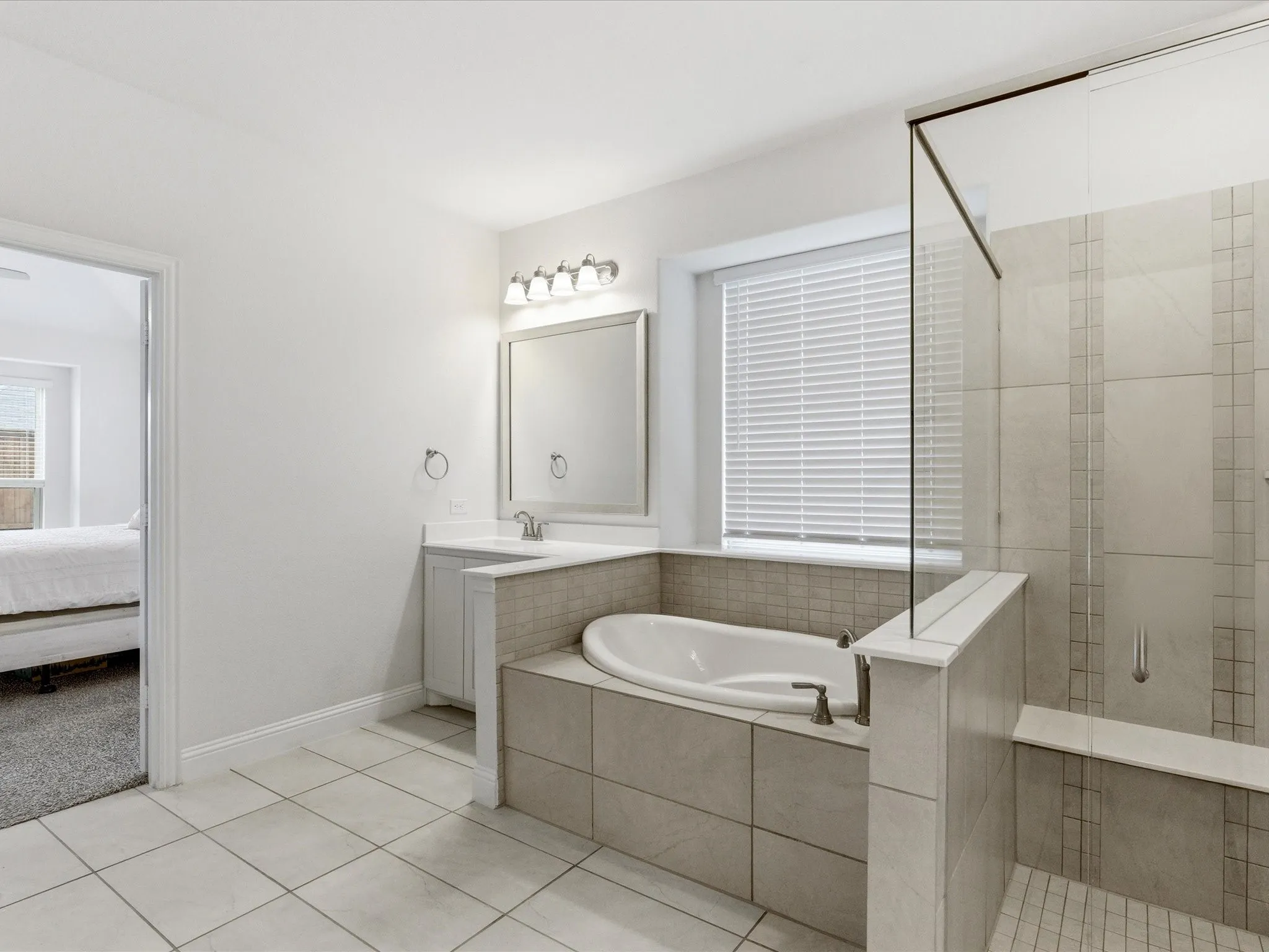 Ensuite bathroom with a stall shower, vanity, a garden tub, and light tile patterned floors