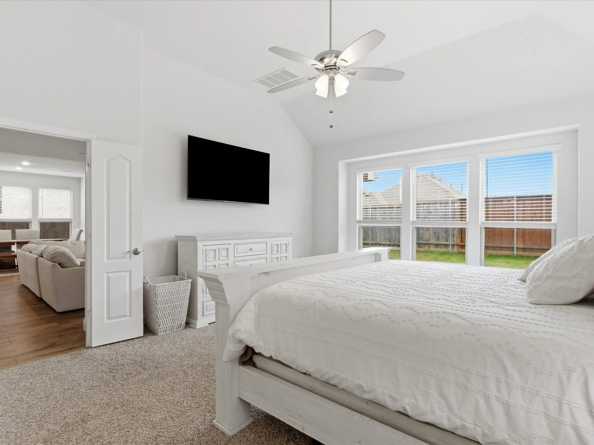 Bedroom with lofted ceiling, light carpet, and ceiling fan