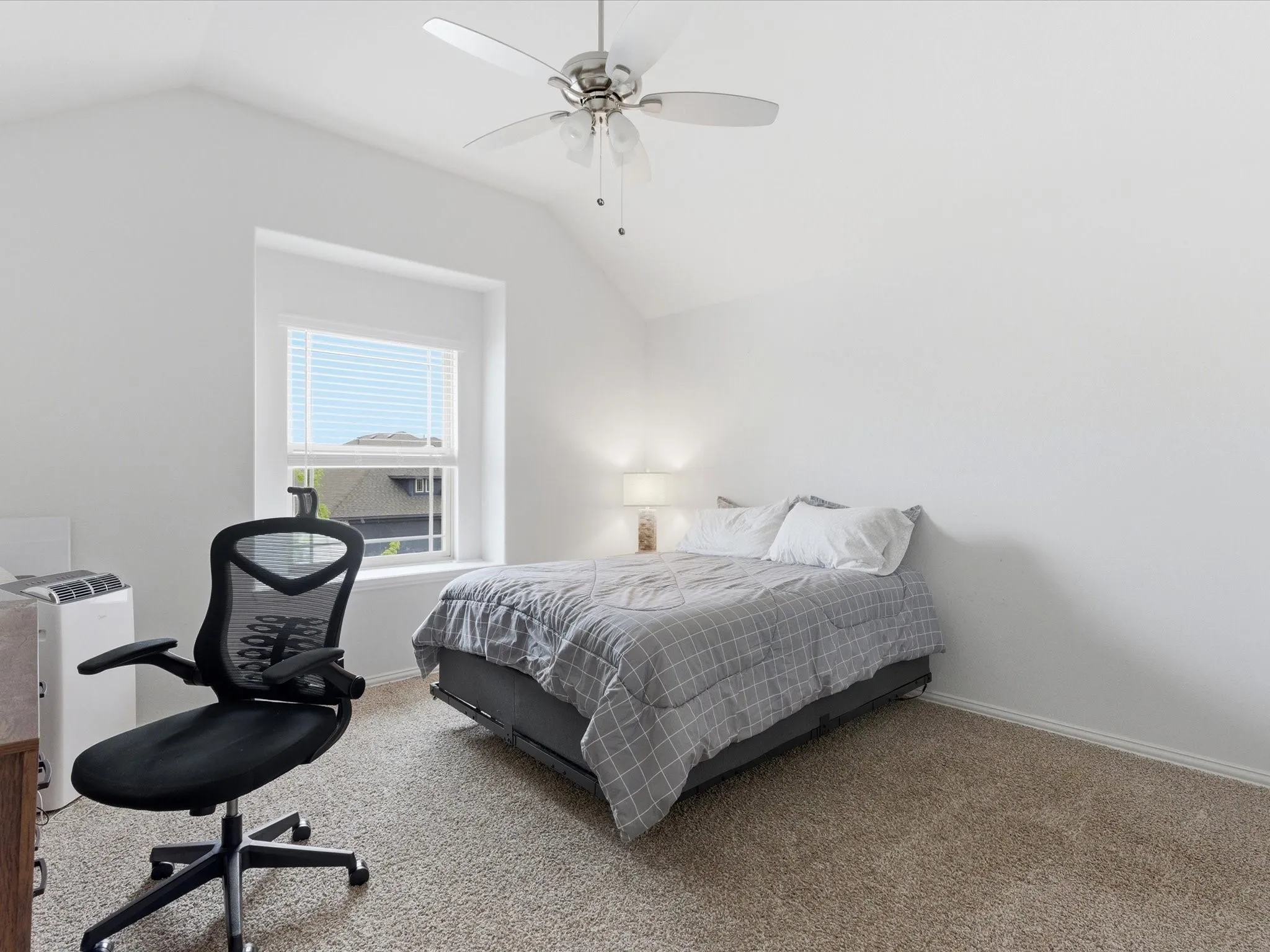 Bedroom with vaulted ceiling, a ceiling fan, and carpet flooring