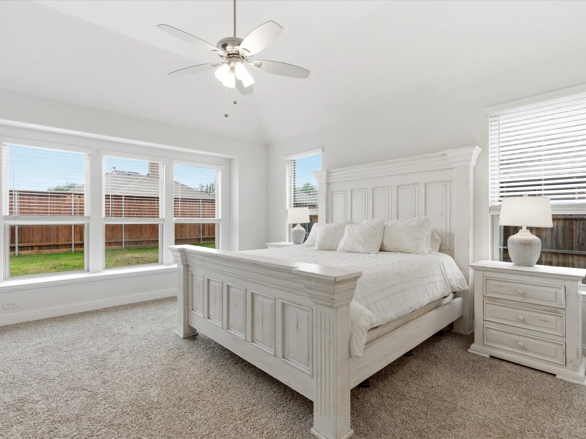 Bedroom with vaulted ceiling, light carpet, and ceiling fan