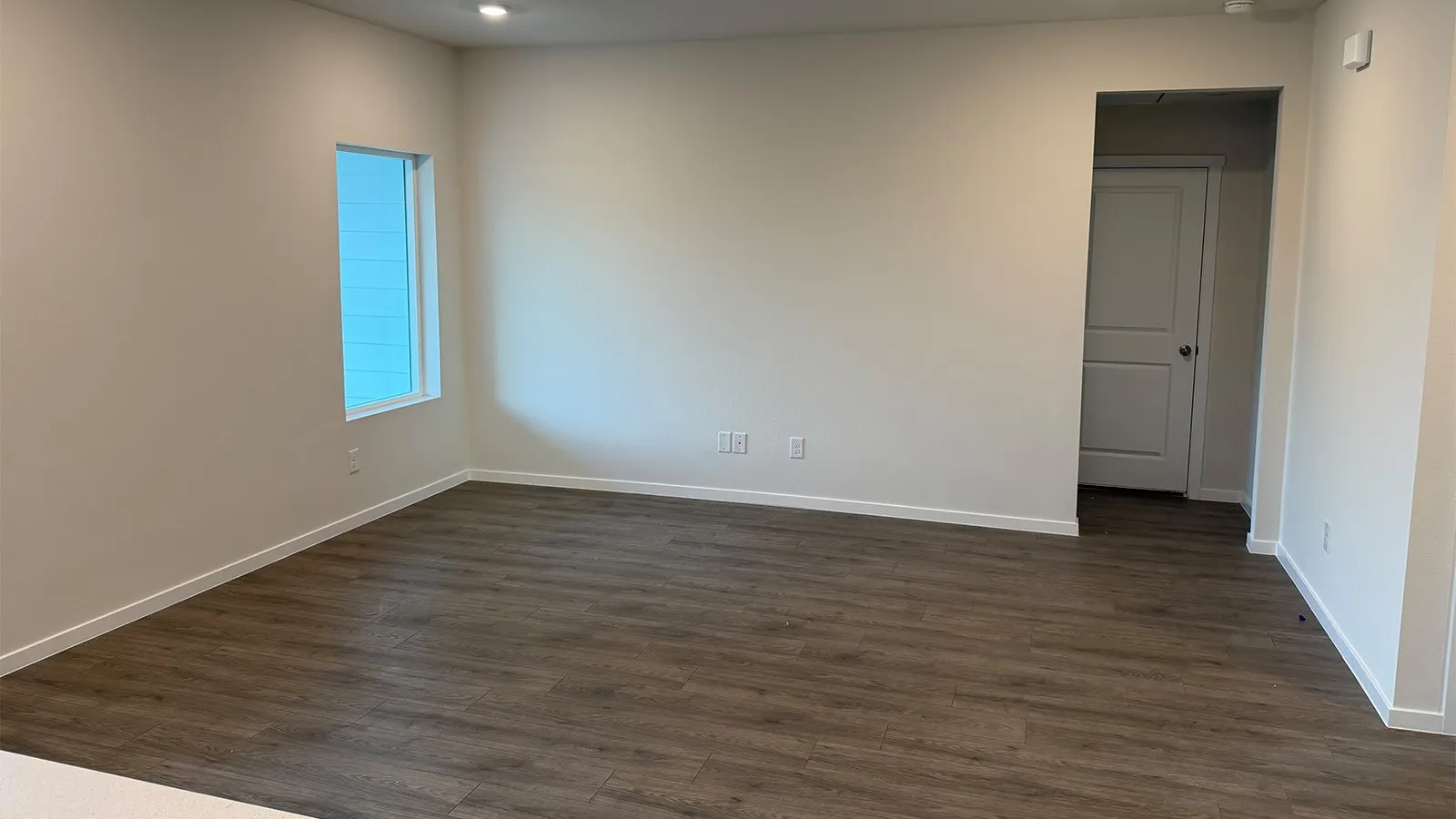 Unfurnished room with dark wood-type flooring and baseboards