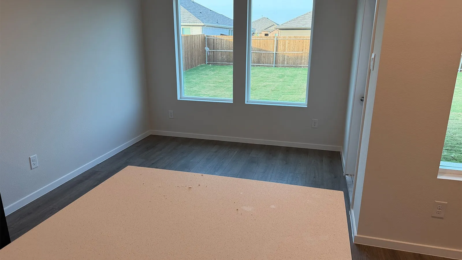 Spare room featuring baseboards and dark wood-style flooring