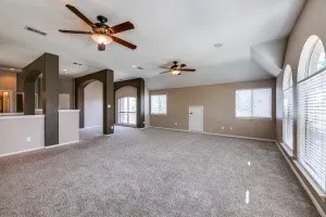 Unfurnished living room featuring a ceiling fan and carpet flooring