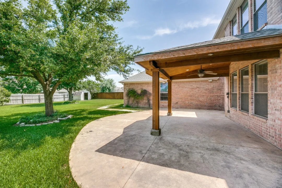 Fenced backyard with a ceiling fan, a patio, and a shed