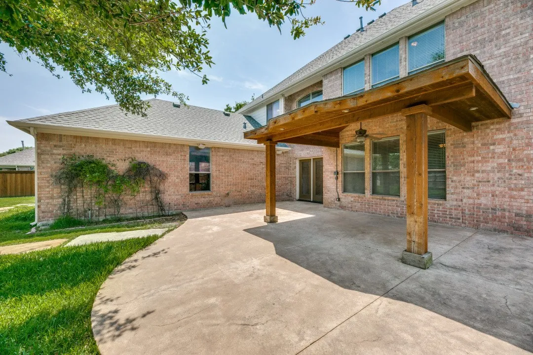 Rear view of house with a patio, brick siding, a shingled roof, and a ceiling fan