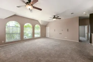 Unfurnished living room with a ceiling fan and carpet floors