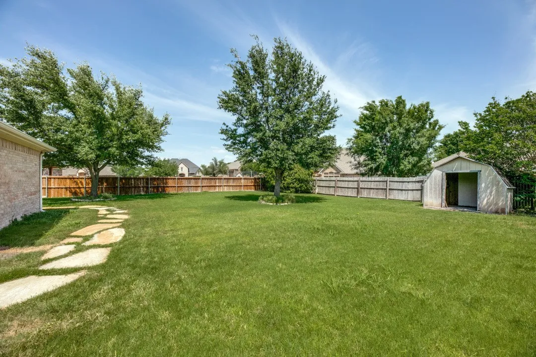Fenced backyard with a storage shed