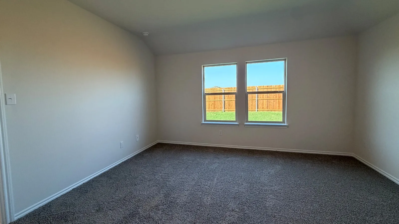 Carpeted interior room featuring light-toned wall paint and white trim