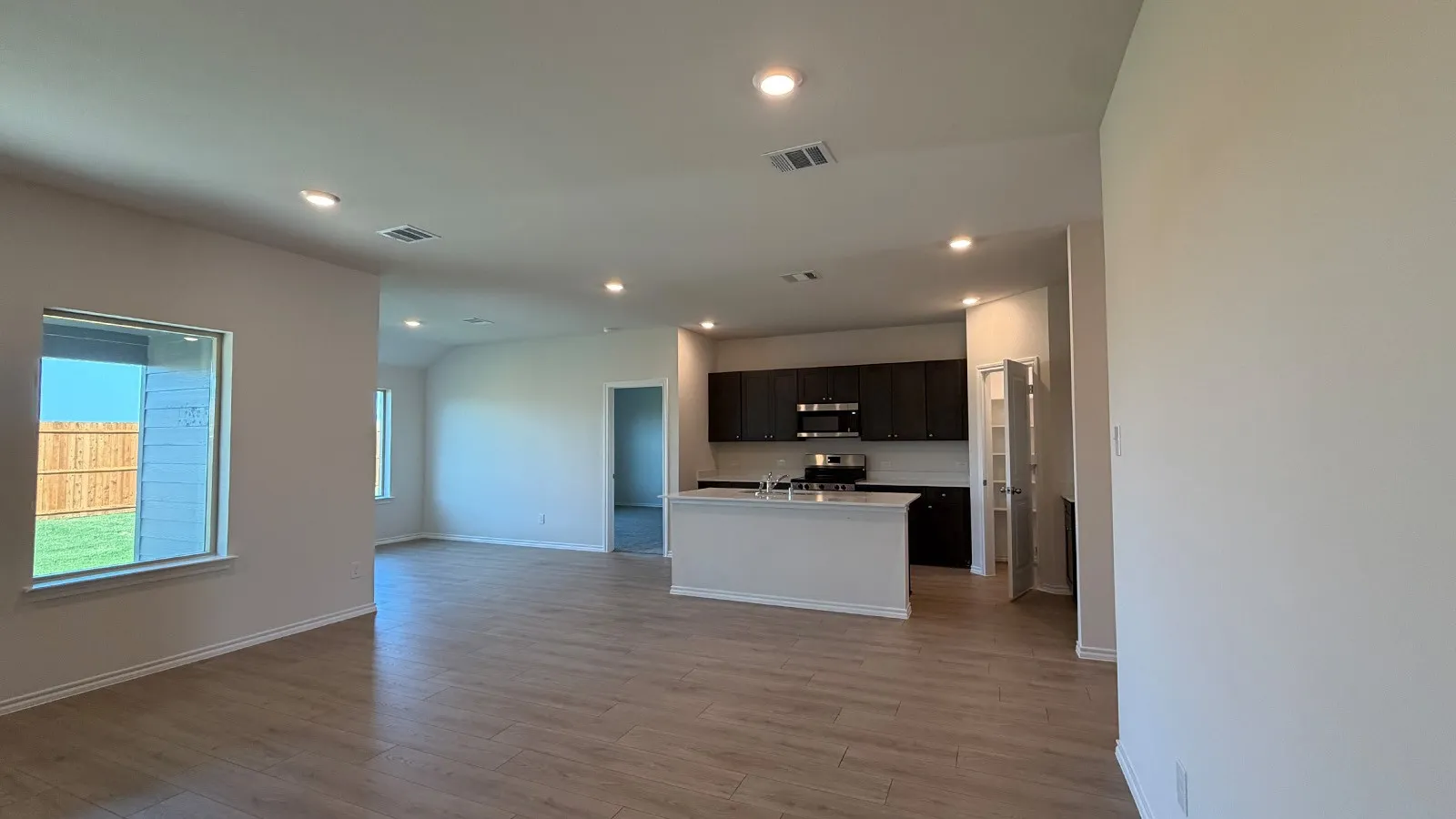 Open concept living space featuring wood-finish flooring and recessed lighting
